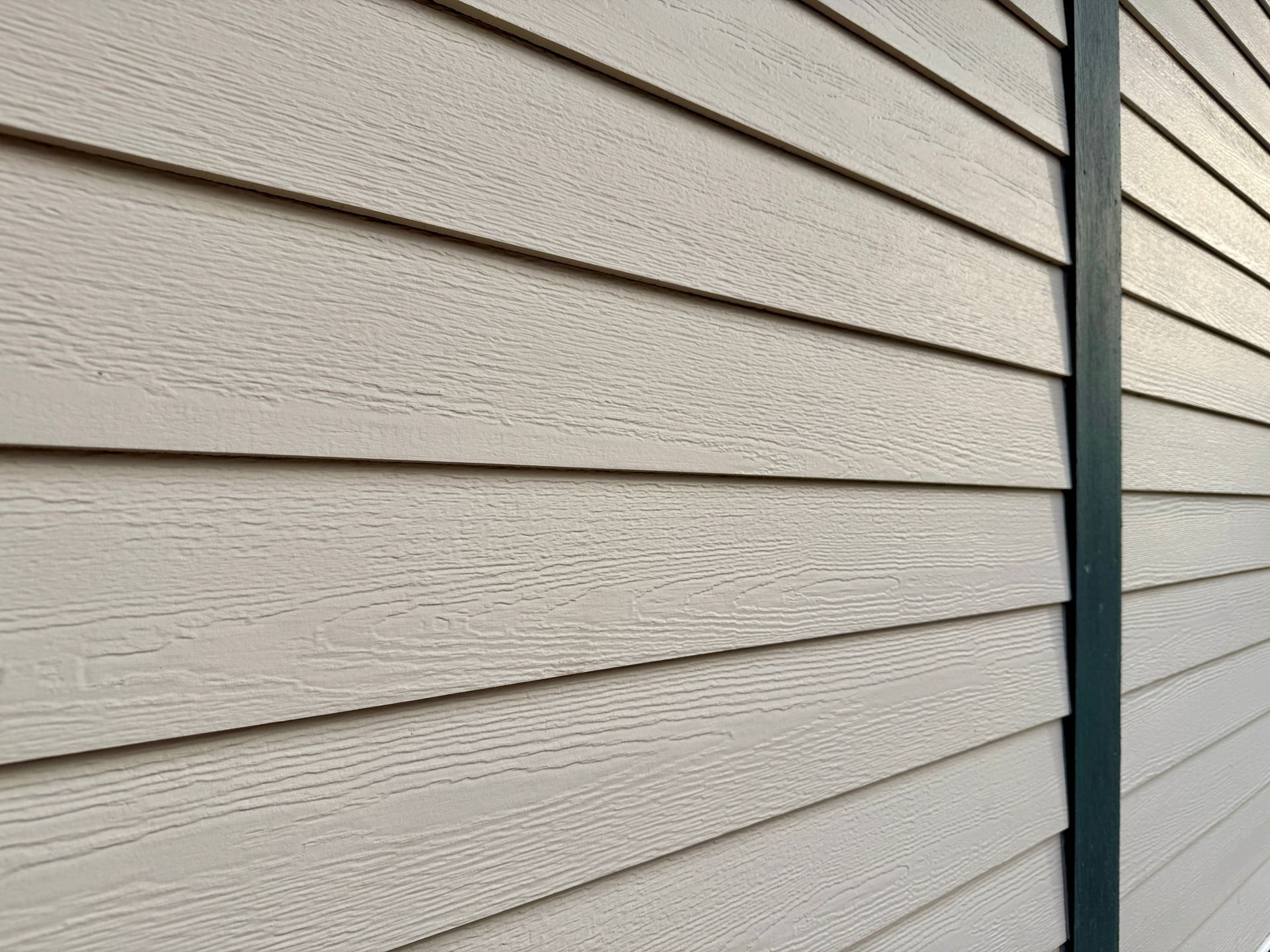 A white house with a black gutter and a garage door.