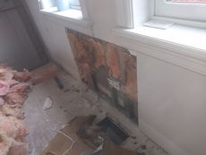 A room with a hole in the wall and a window.