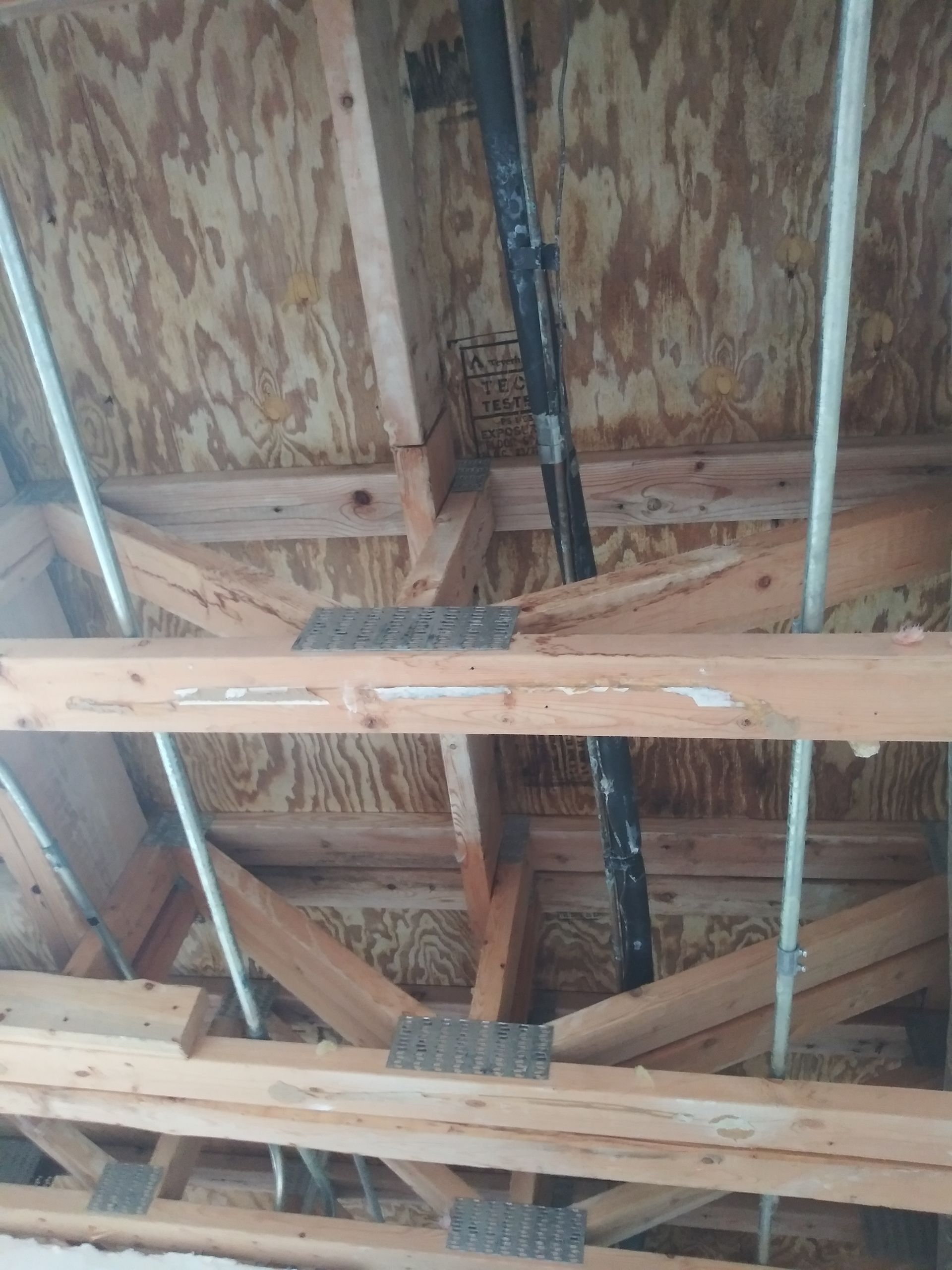 The ceiling of a building is made of wood and metal.