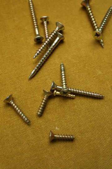 A bunch of screws are laying on a table