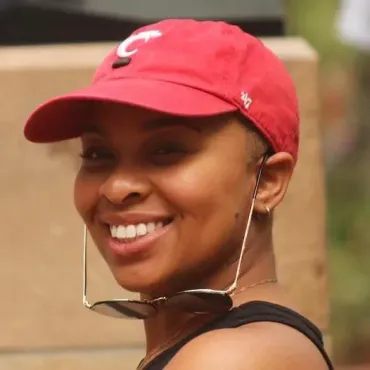 A woman wearing a red hat with the letter c on it