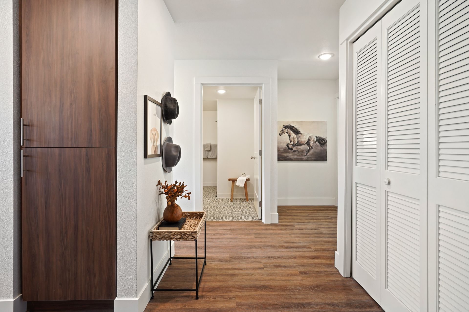 There is a picture of a horse on the wall in the hallway.