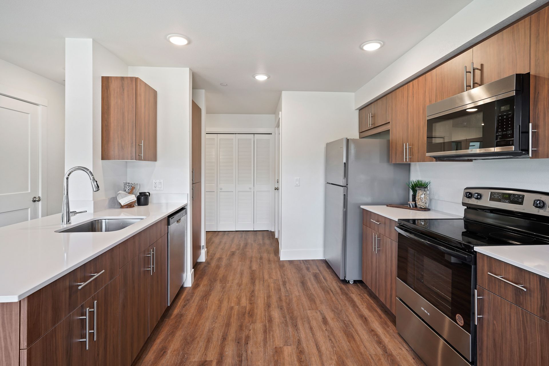 A kitchen with stainless steel appliances and wooden cabinets.