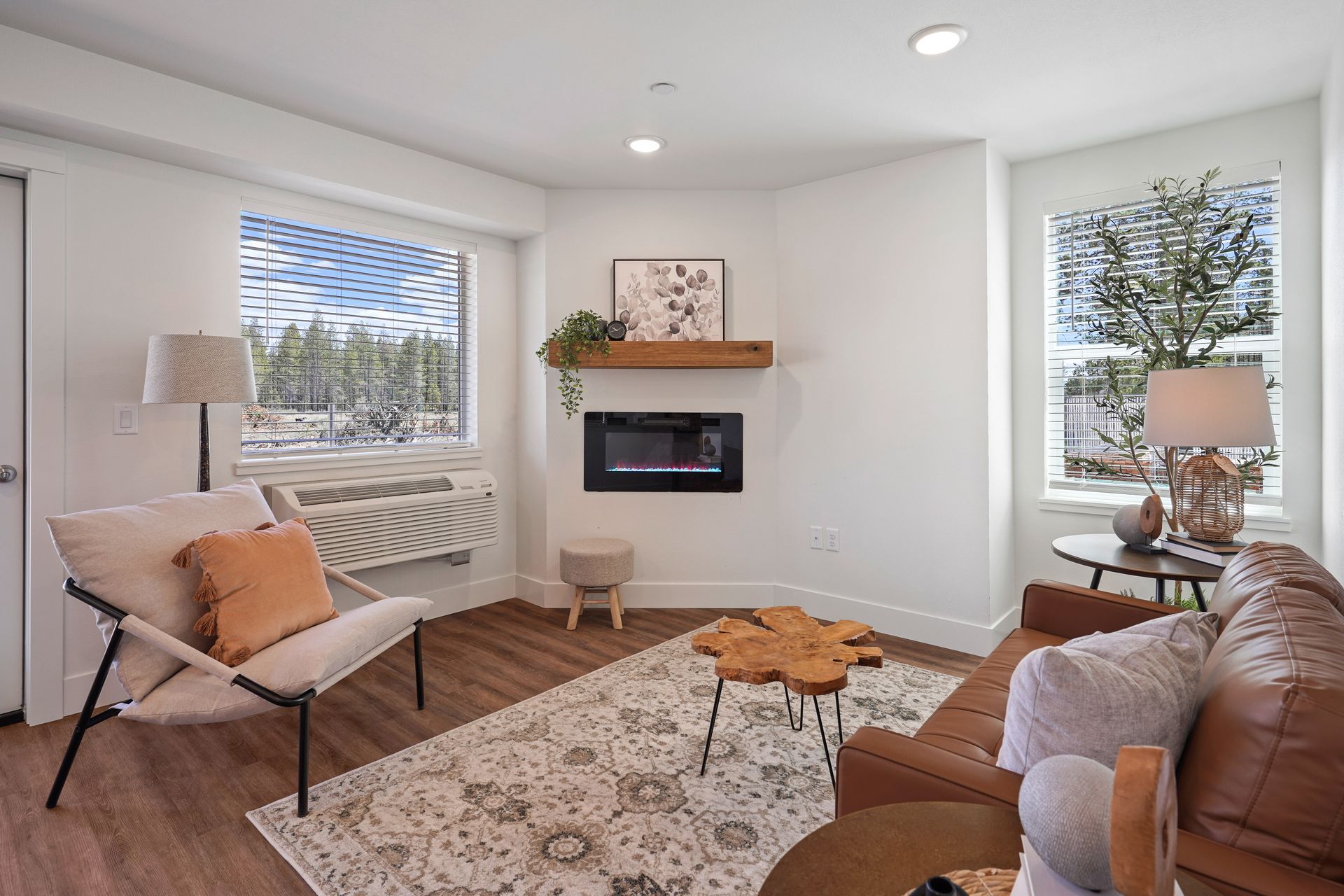 A living room with a couch , chair , table and fireplace.