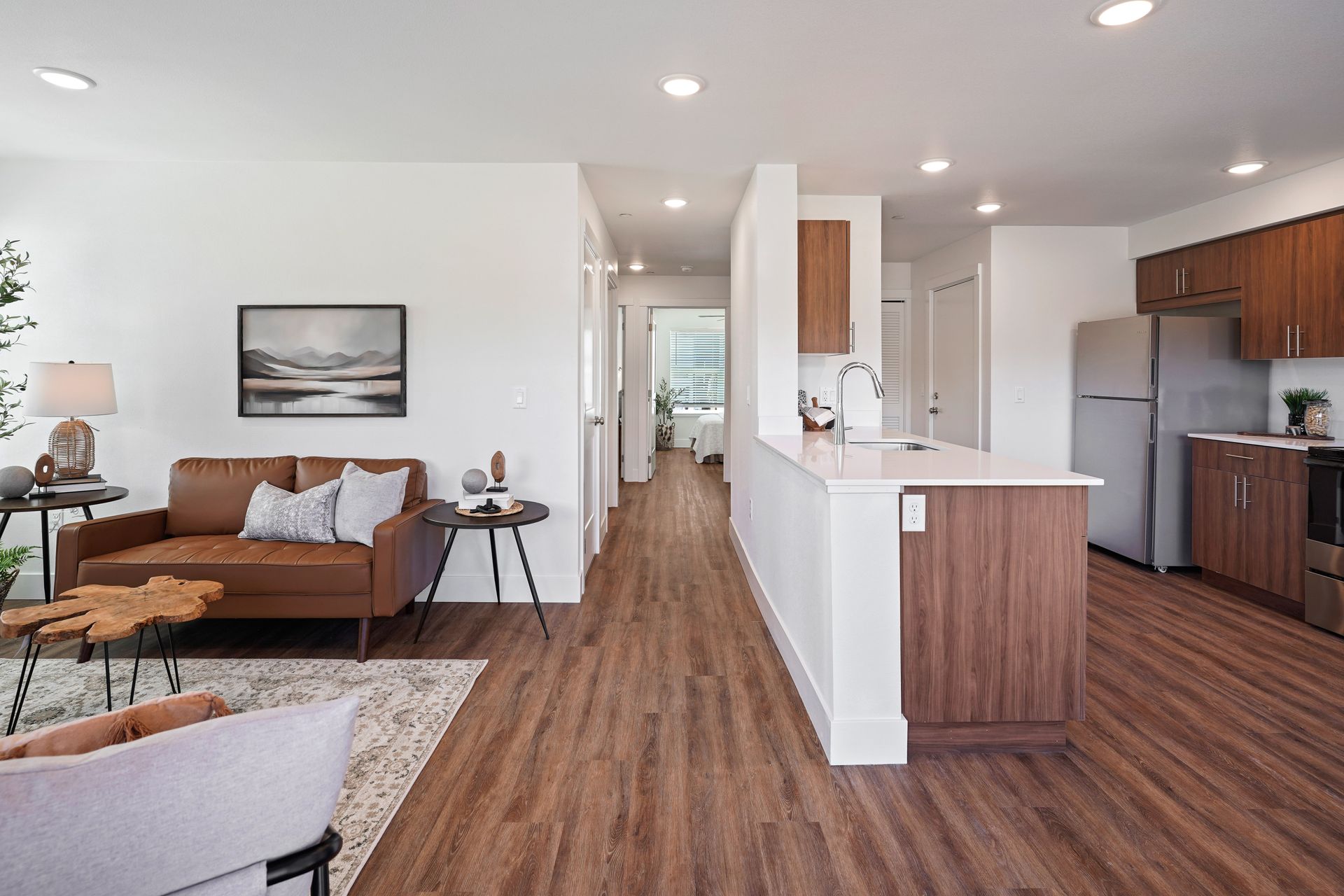 A living room and kitchen in a house with hardwood floors.