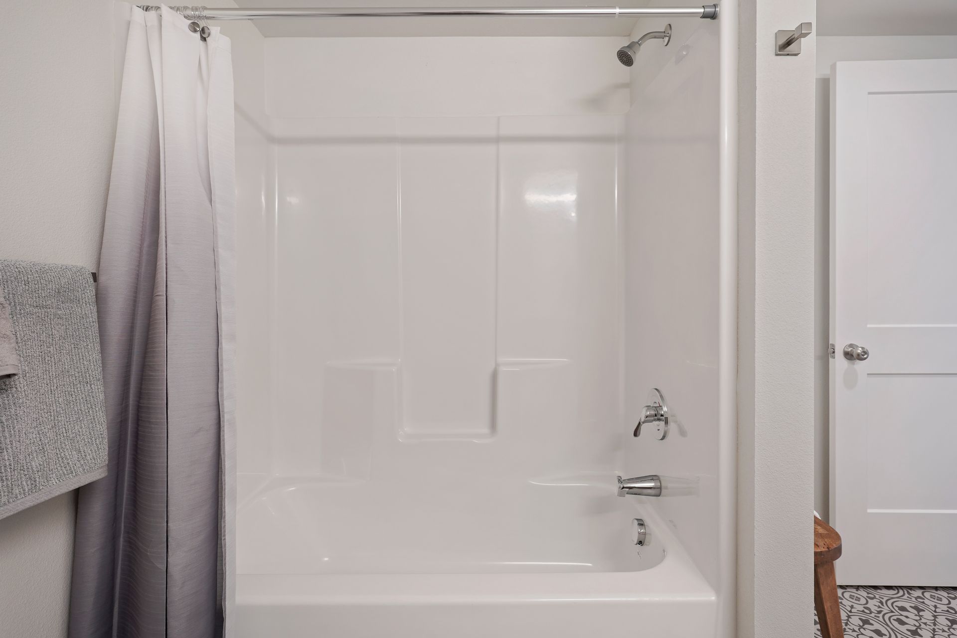 A bathroom with a bathtub and shower curtain.