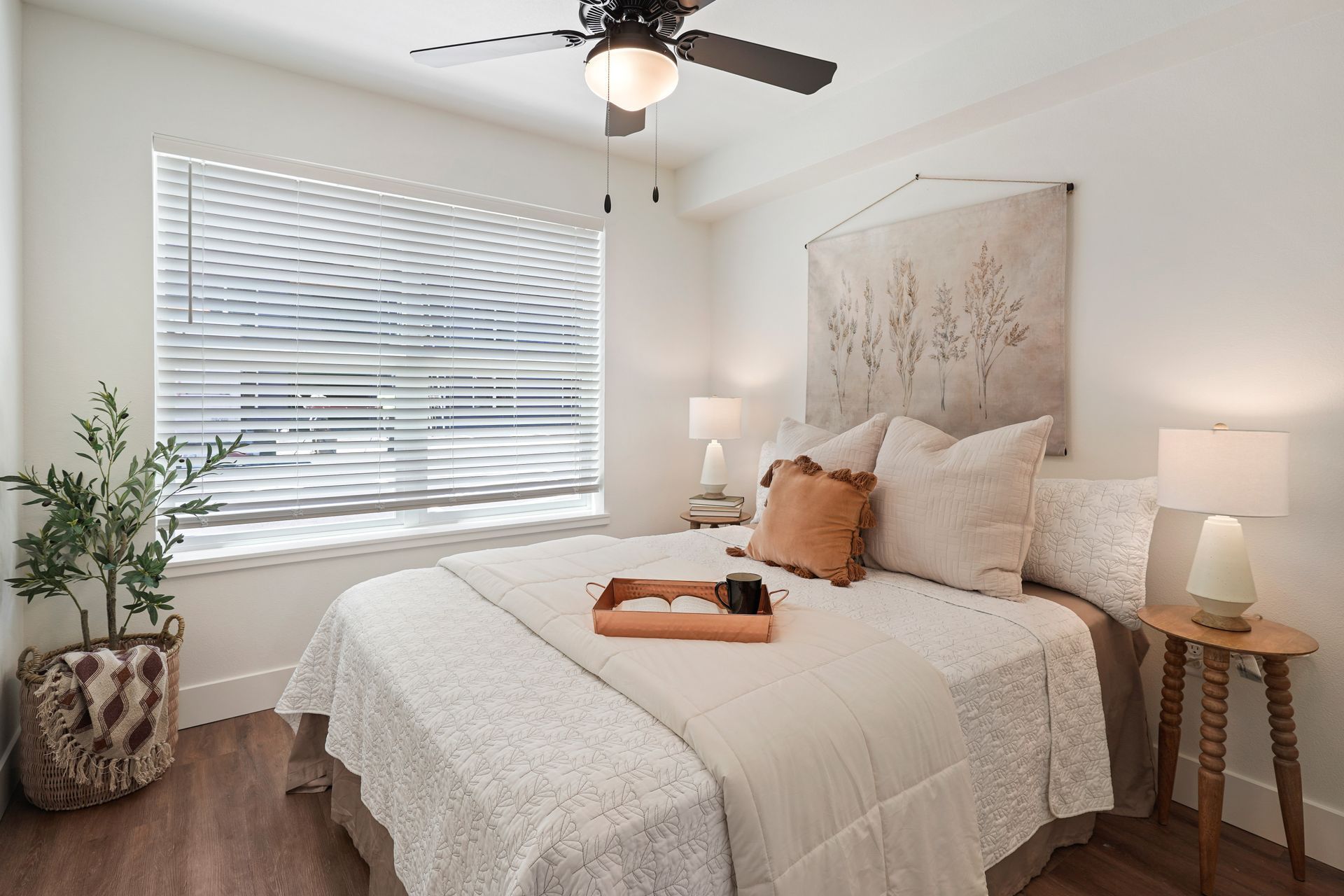 A bedroom with a bed and a ceiling fan.