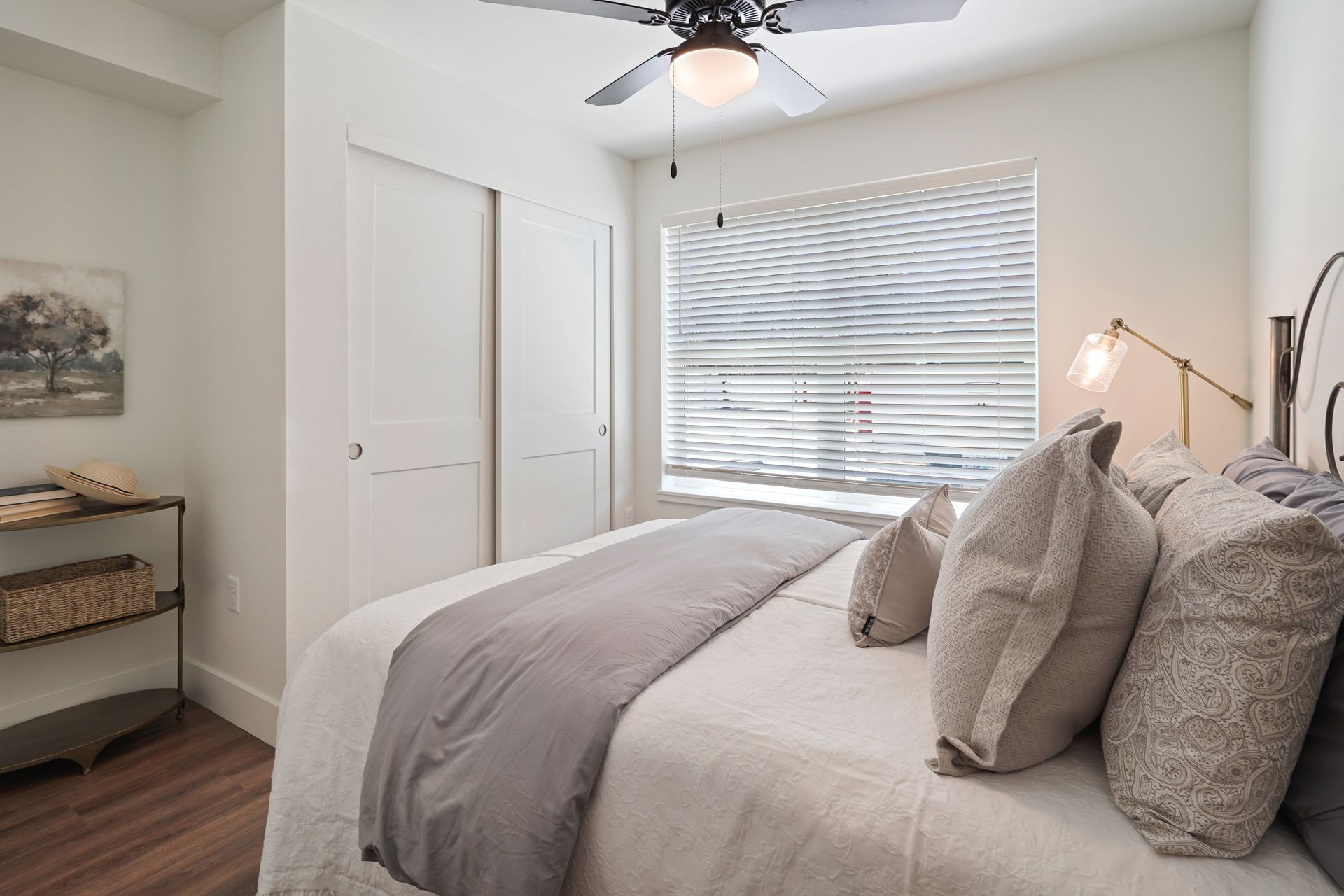 A bedroom with a large bed and a ceiling fan.