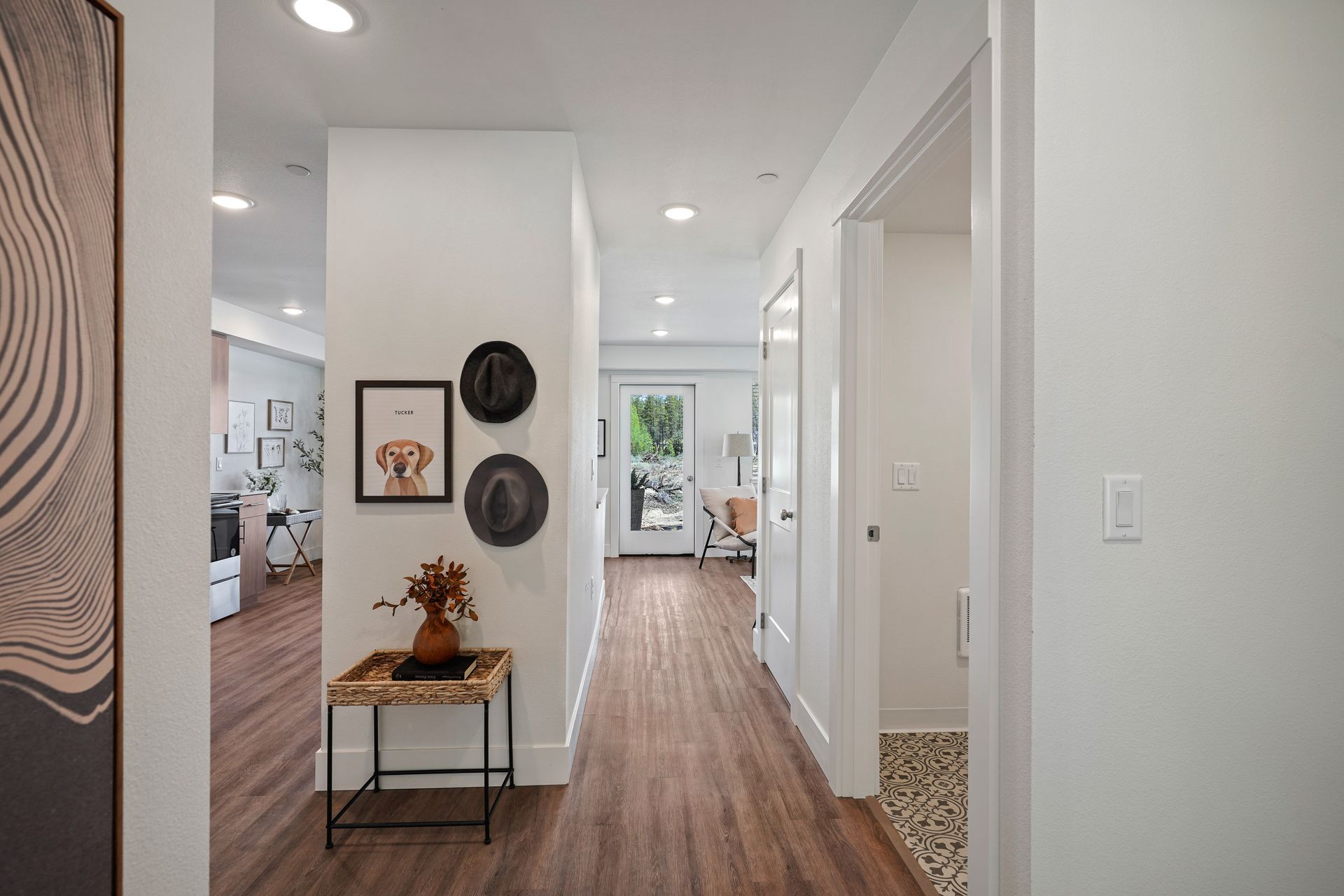 A hallway in a house with wooden floors and white walls.