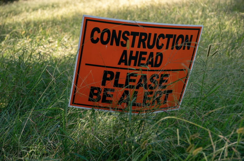 An orange construction sign reading
