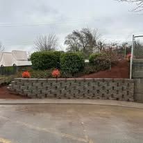 There is a brick wall in the middle of a parking lot.