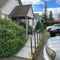 A car is parked in front of a house with a ramp leading to it.