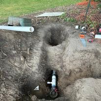 A pipe is being installed in a hole in the ground.