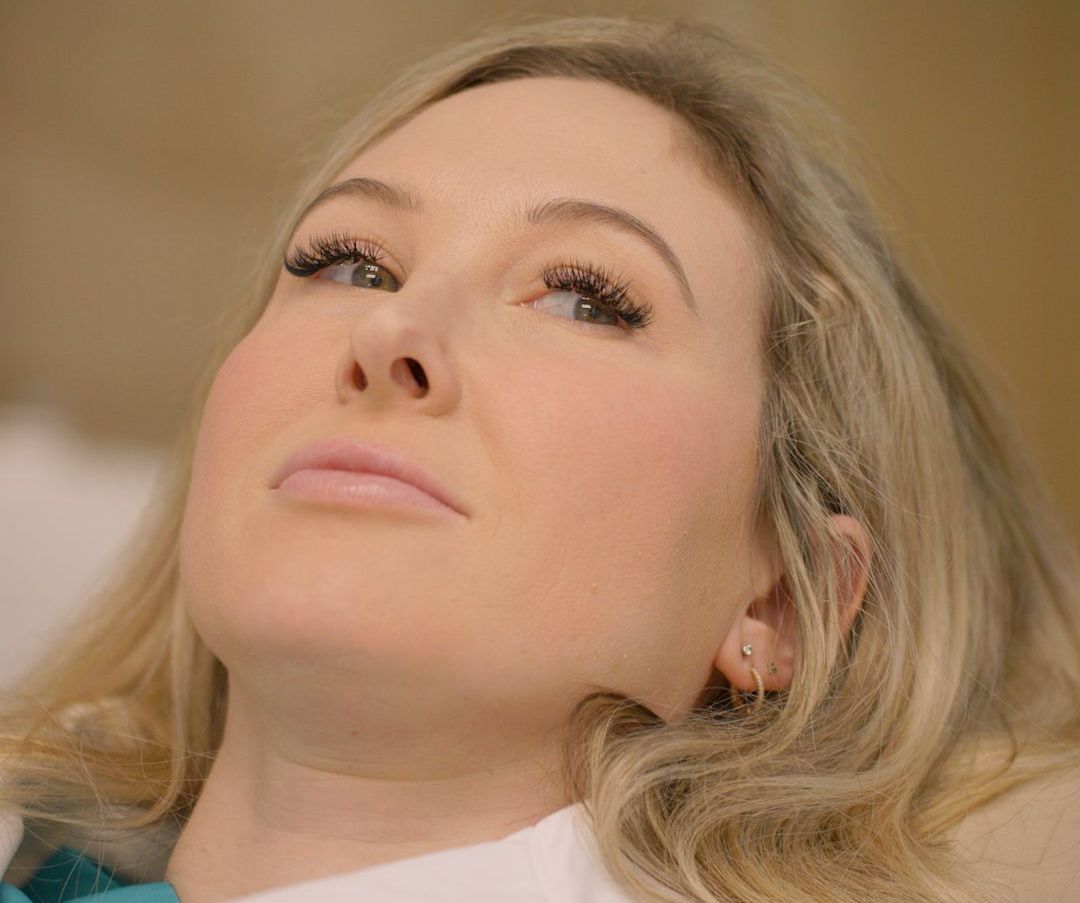 A close up of a woman 's face looking up at the sky.