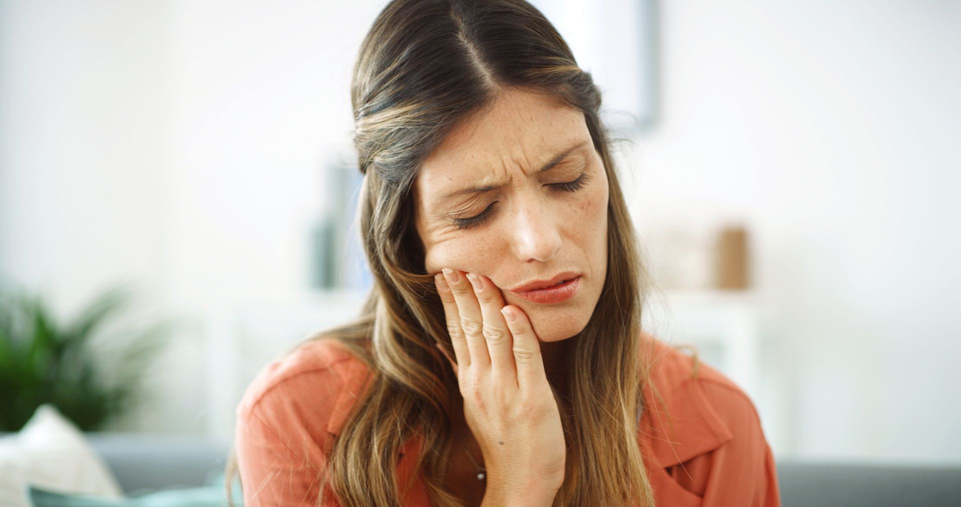 Person touching their cheek as they experience tooth pain that may need a root canal. Person touching their cheek as they experience tooth pain that may need a root canal.