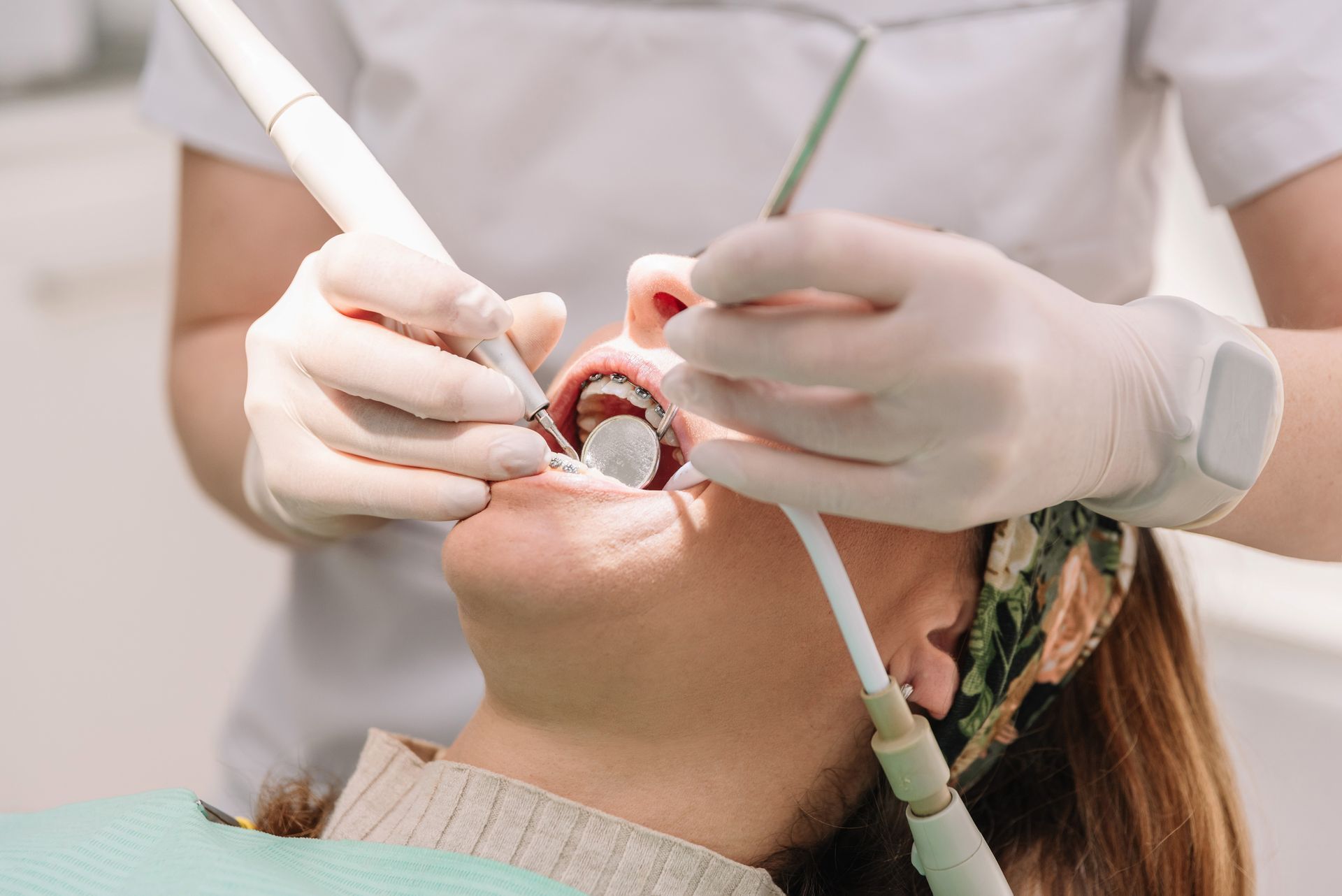 Dentist performing dental exam on female patient using professional tools in a modern dental clinic. Dentist performing dental exam on female patient using professional tools in a modern dental clinic.