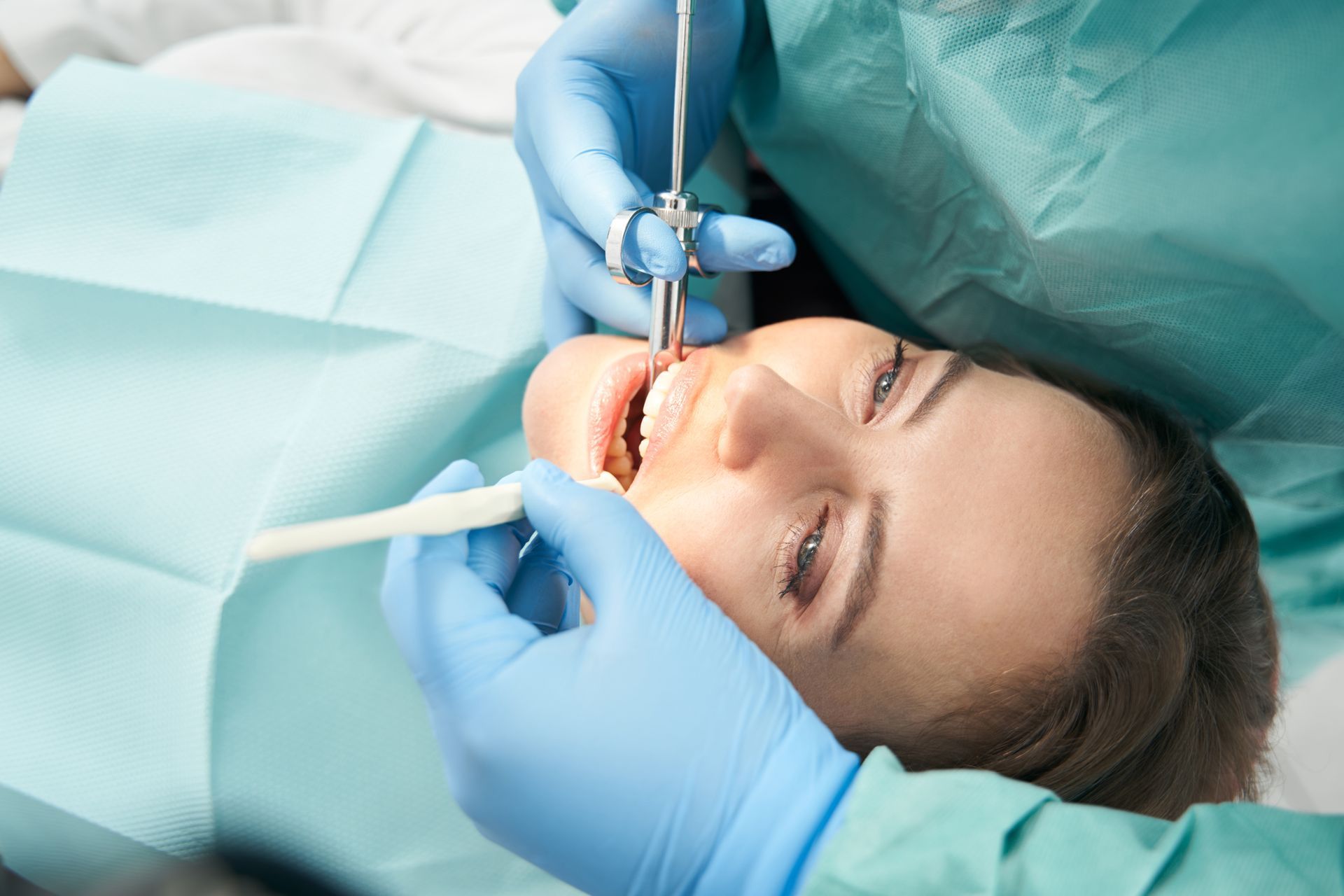 A dental professional inspecting a tooth for a root canal. A dental professional inspecting a tooth for a root canal.