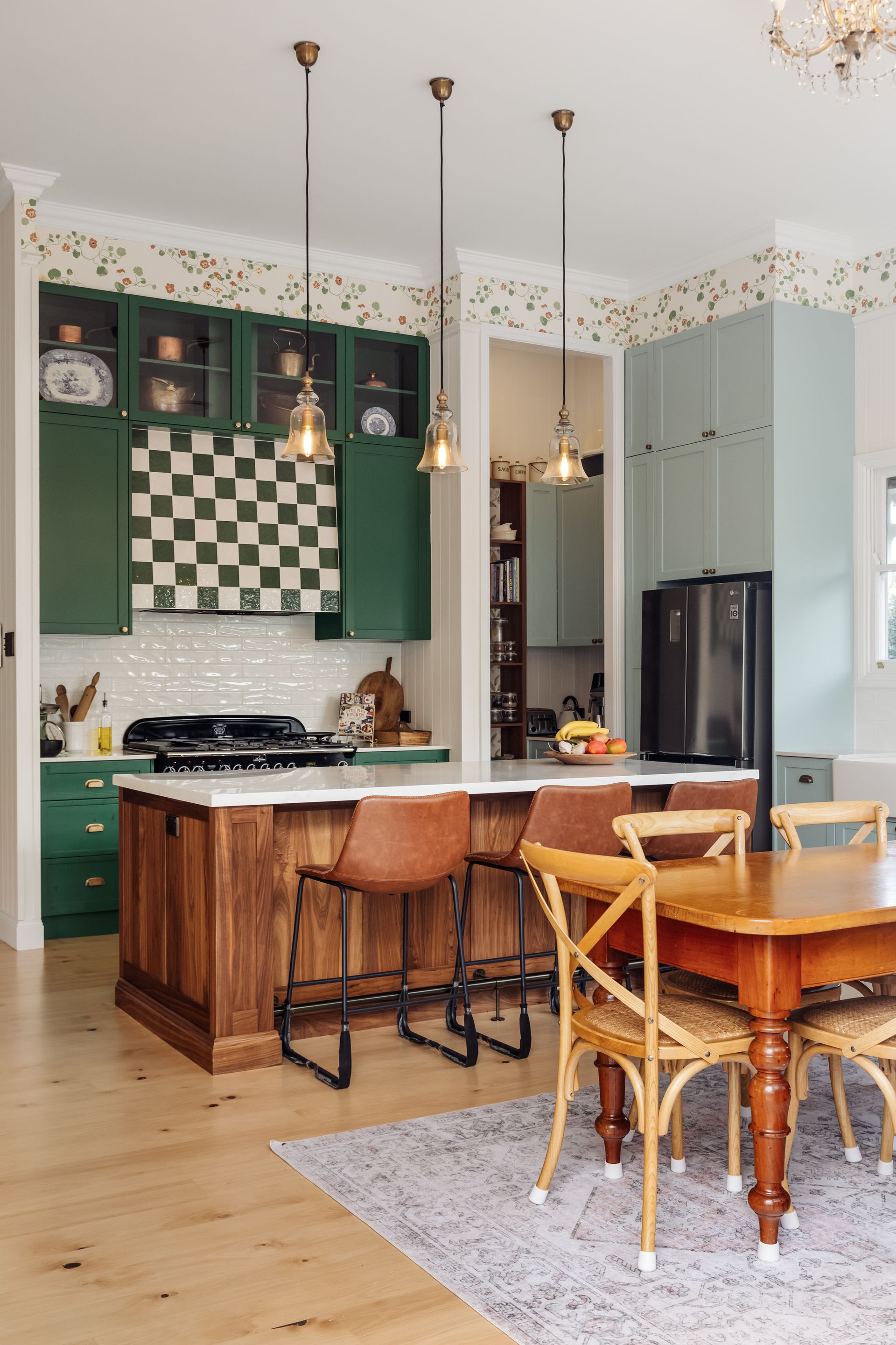 a kitchen with white cabinets , a large island , a stove , and a window .