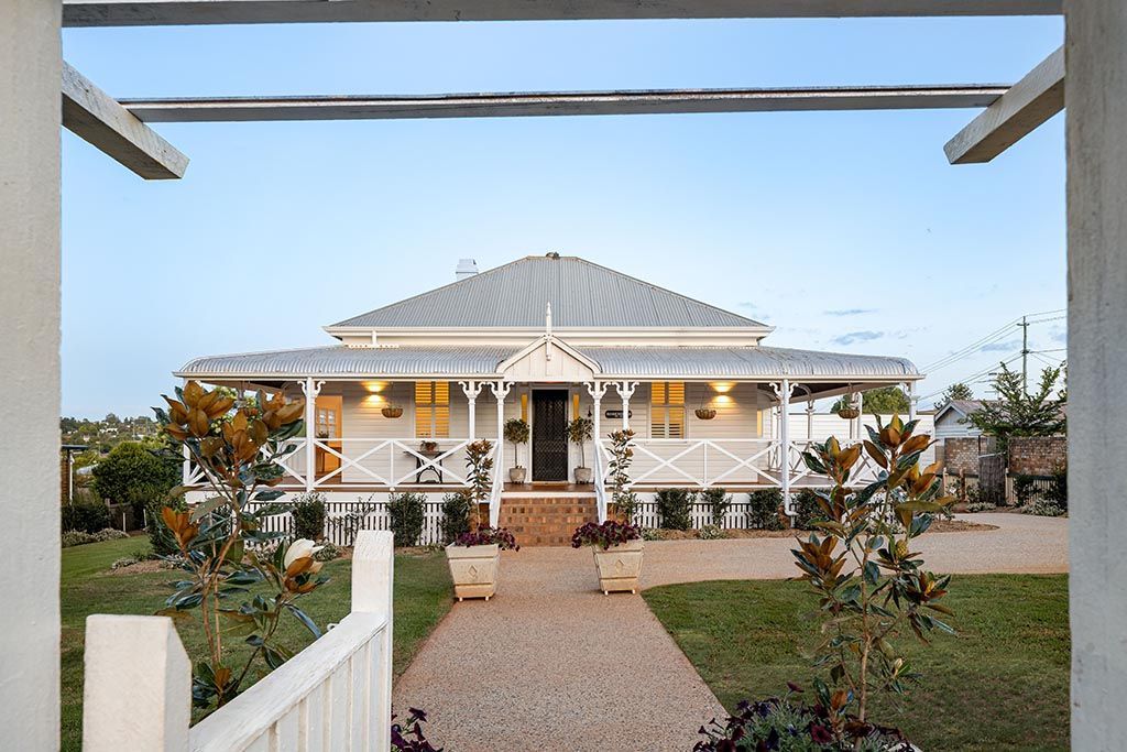 a large white house with a porch and a walkway leading to it