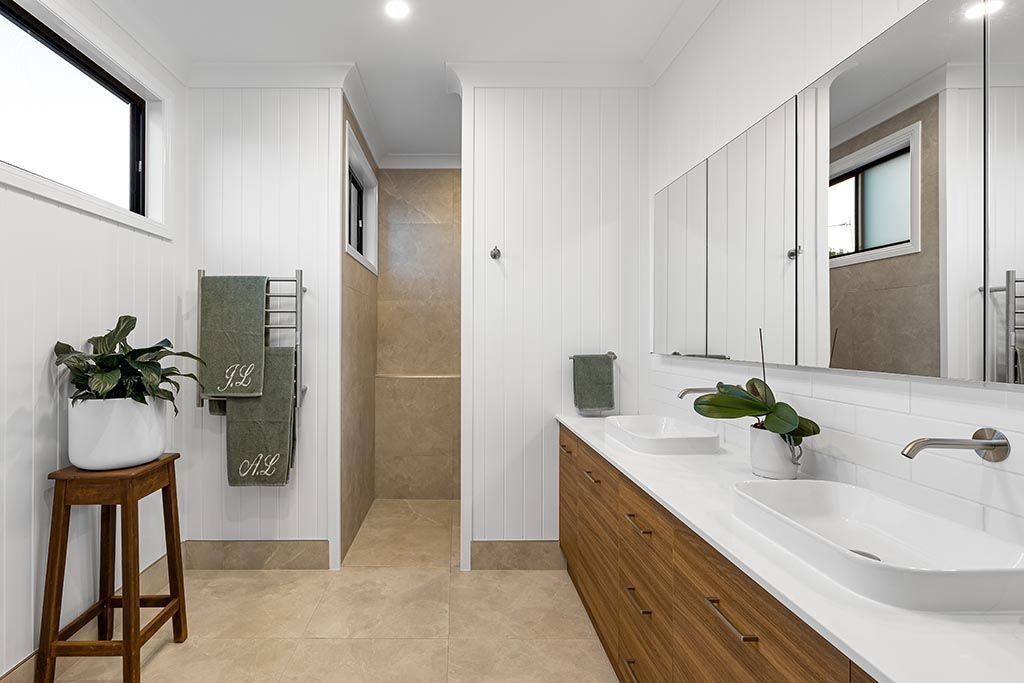 a bathroom with two sinks and a walk in shower