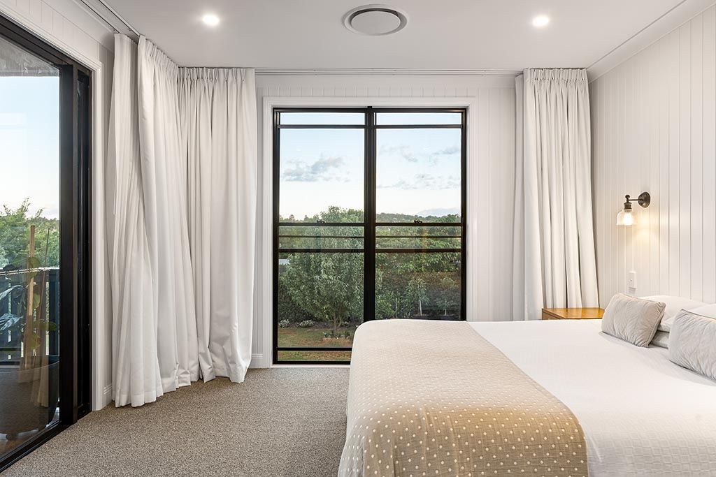 a bedroom with a bed , sliding glass doors and a balcony .