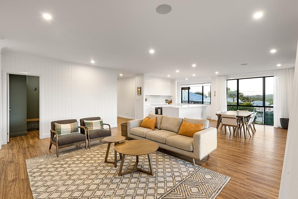 a living room with a couch , chairs , tables and a rug .