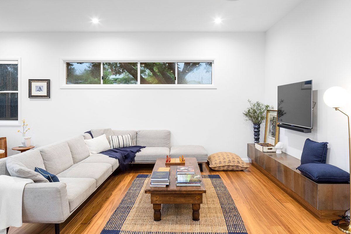a living room with a couch , coffee table , and television .