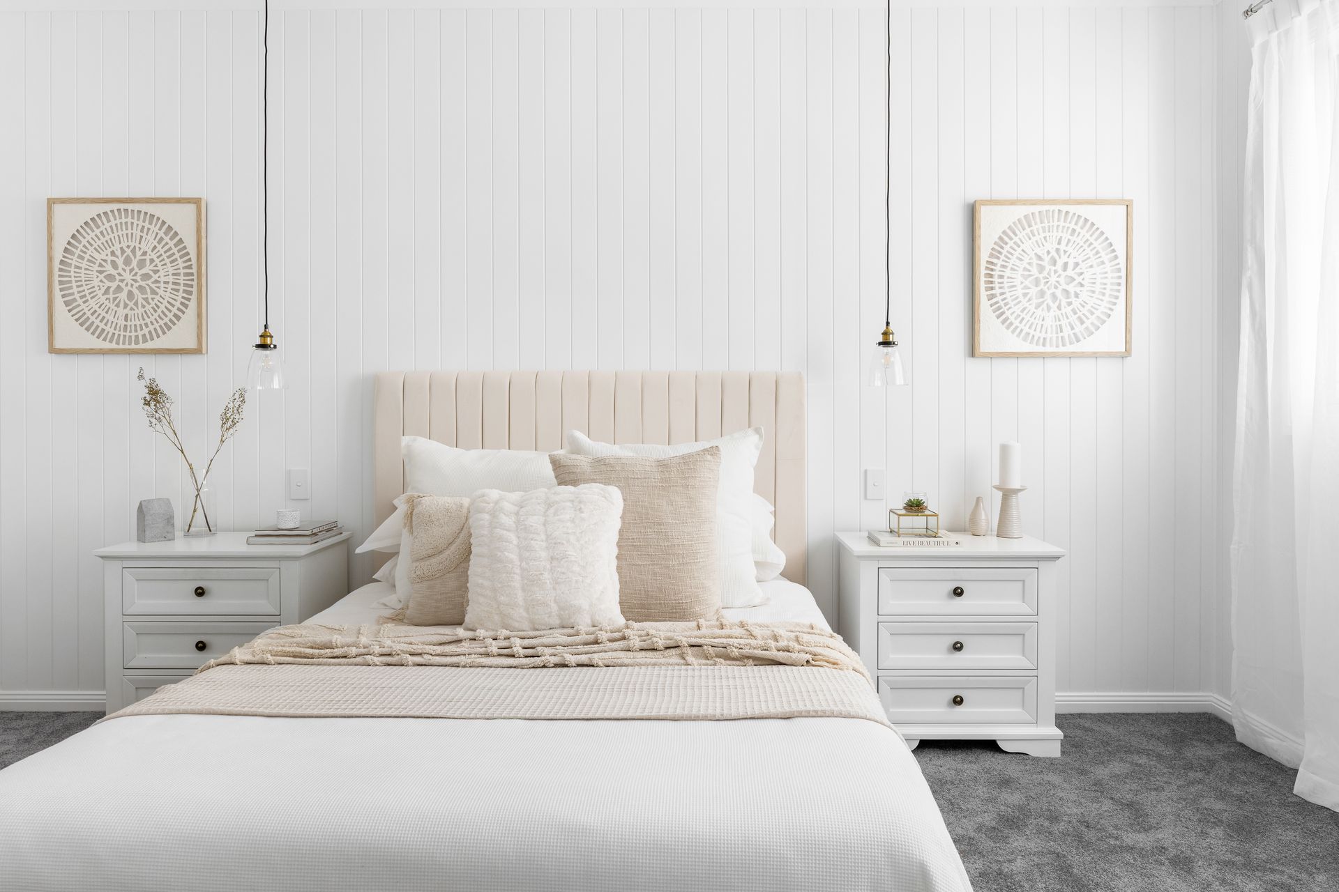 a bedroom with a bed , two nightstands , and two paintings on the wall .