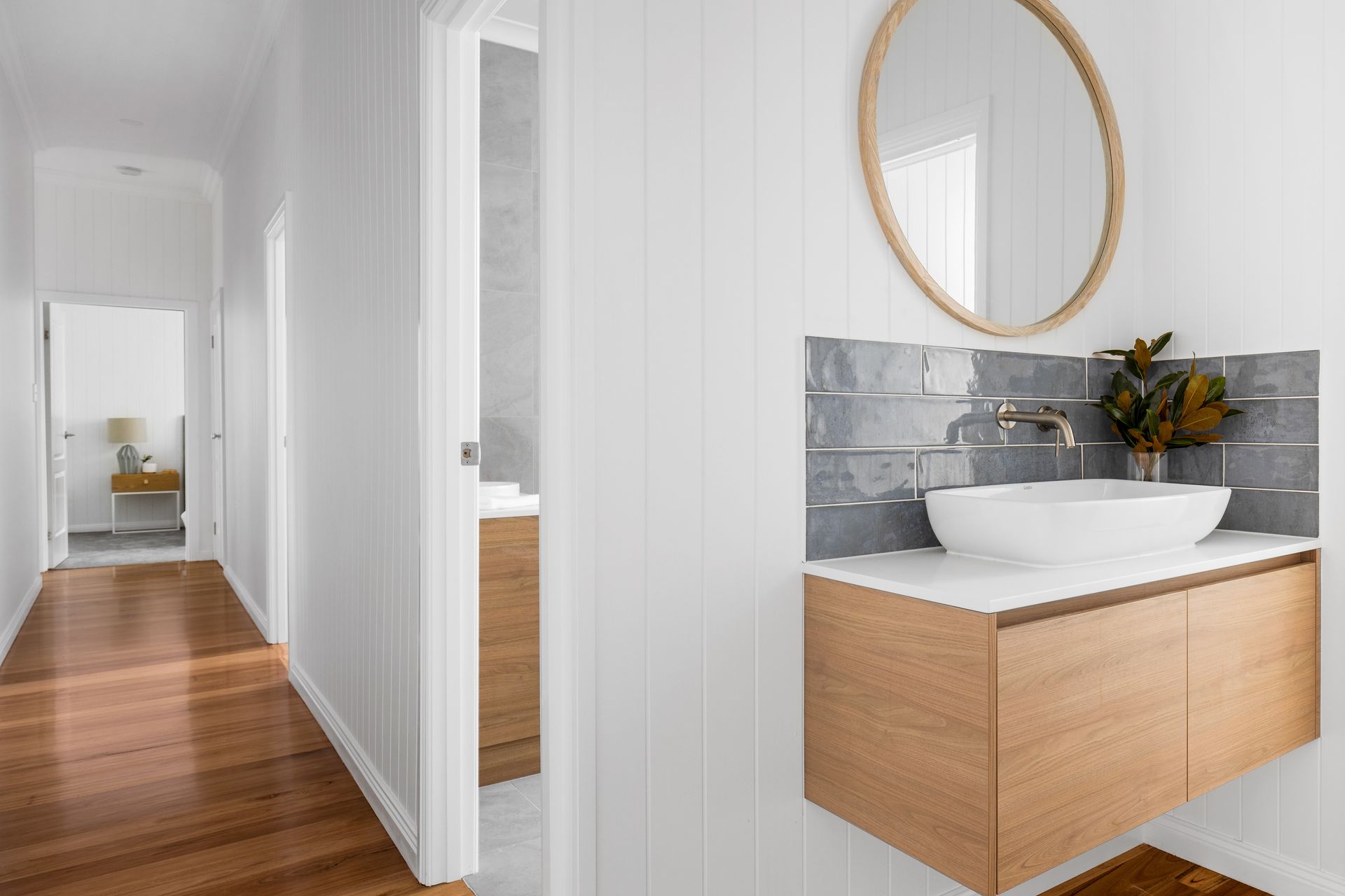 a bathroom with a sink , mirror and wooden cabinets .