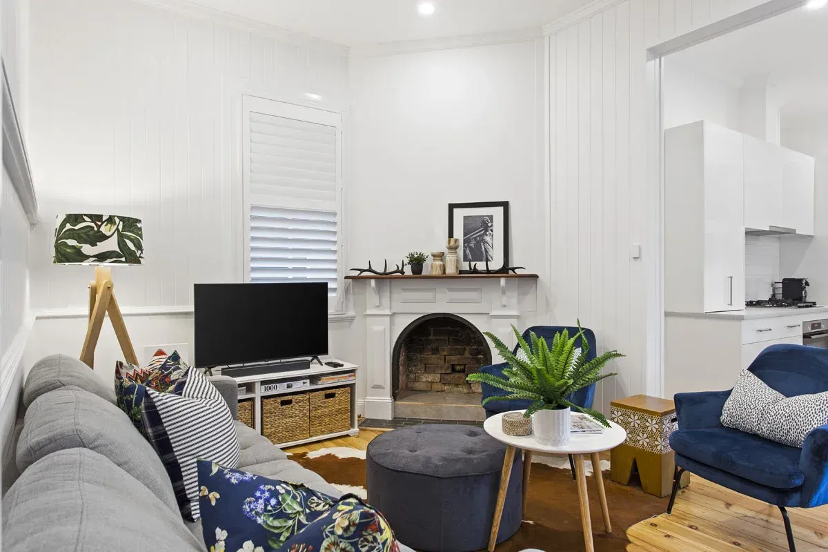 a living room with a couch , chair , table and television .