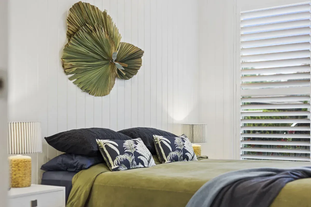 a bedroom with a bed , lamps , and a wall decoration .