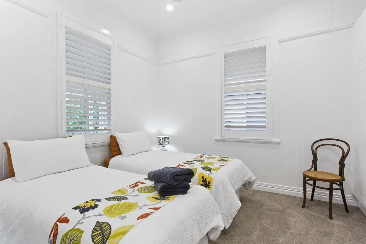 a bedroom with two beds and a chair in it