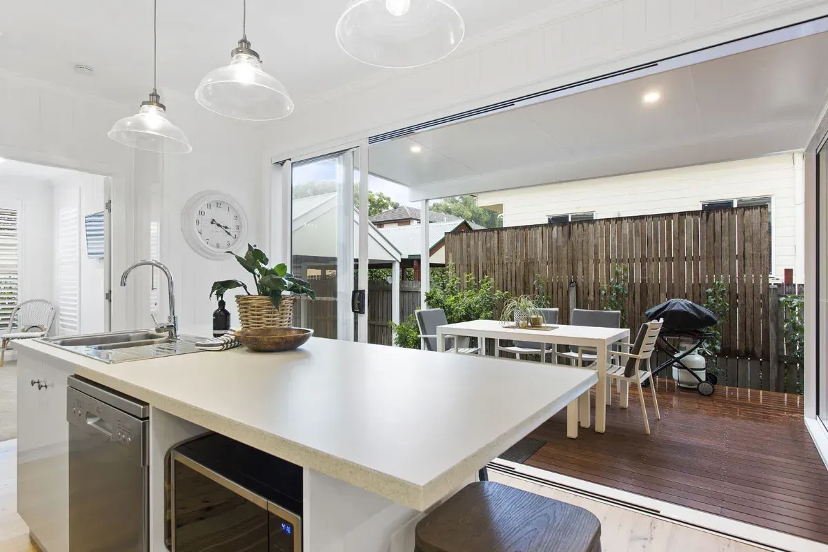 a kitchen with a large island and a sliding glass door leading to a patio .