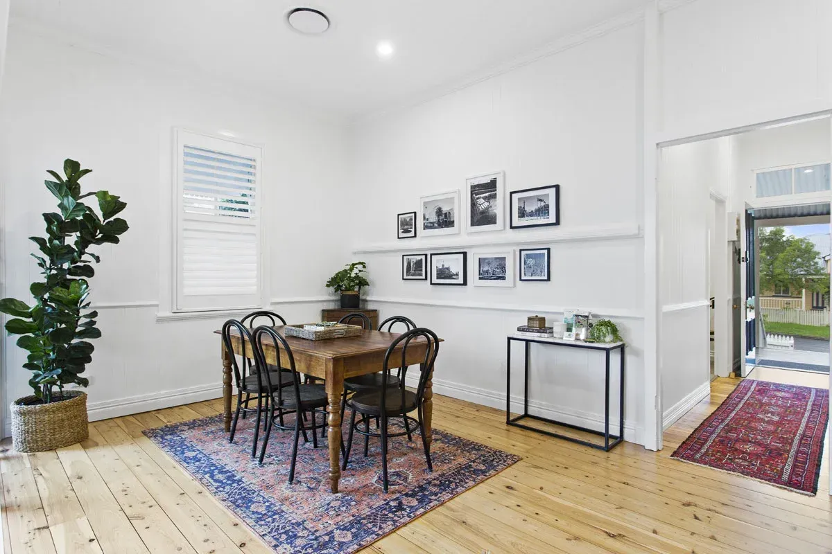 a dining room with a wooden table and chairs and a rug on the floor .