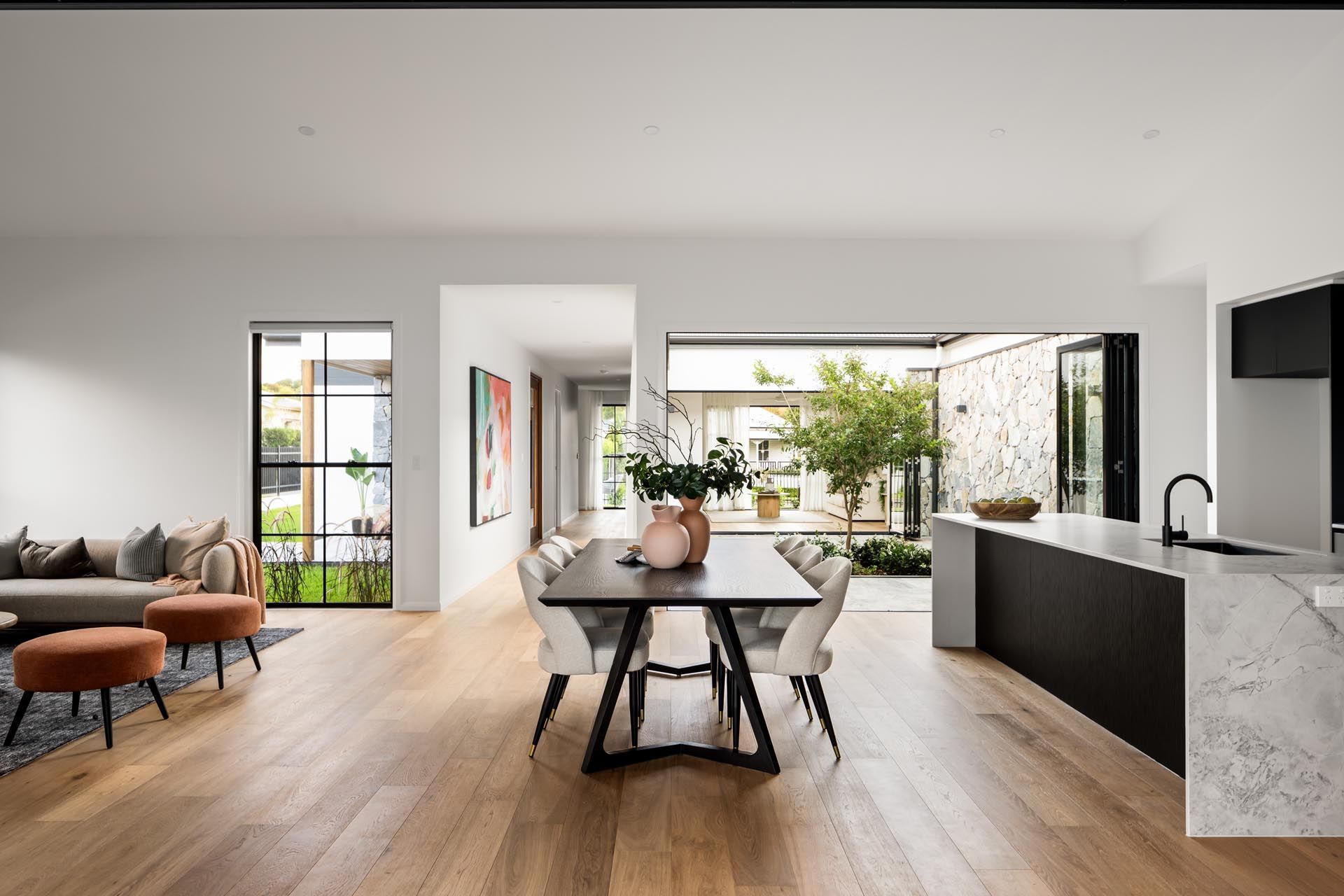 An open plan kitchen/dining area with a table and chairs in the middle of the room.