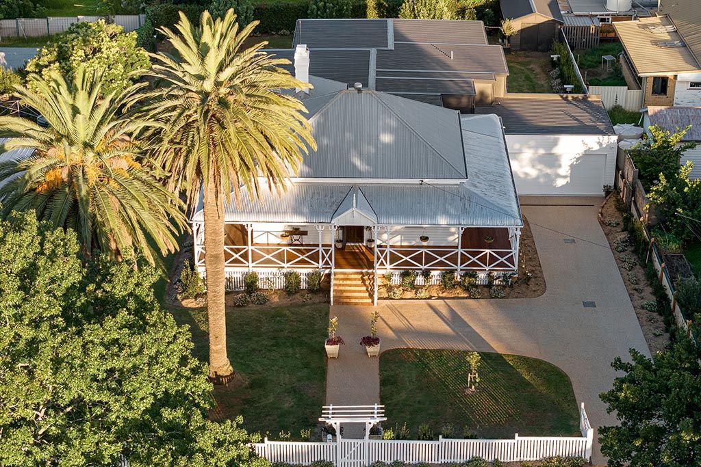 an aerial view of a house with palm trees in front of it