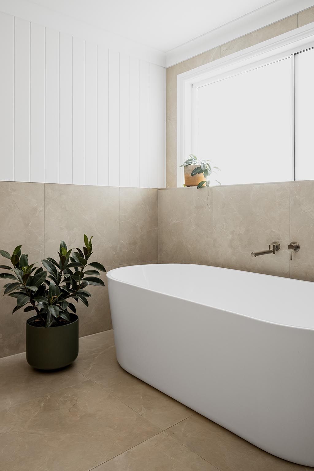 a bathroom with a bathtub and a potted plant .