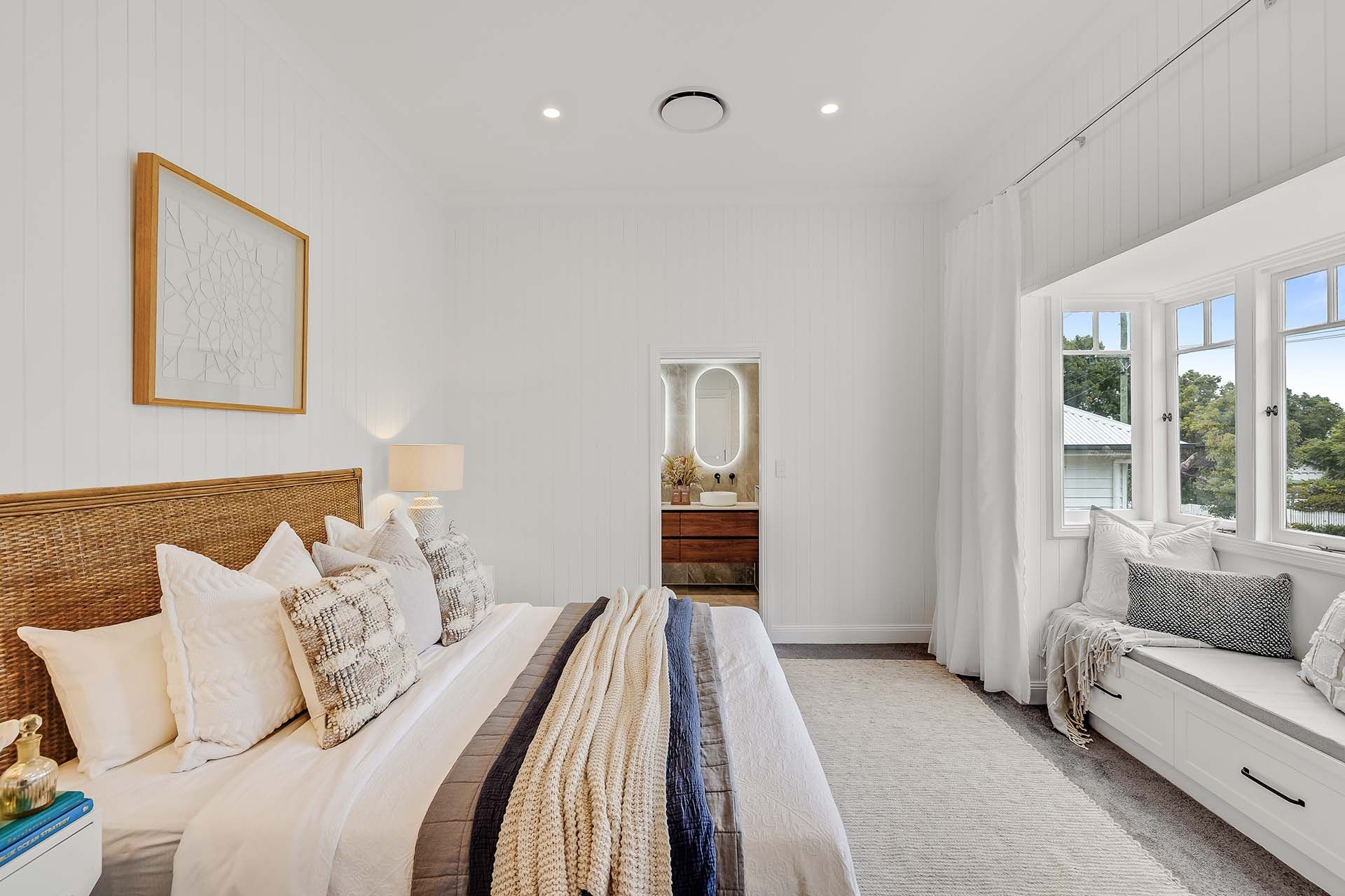 a bedroom with a large bed and a window seat .