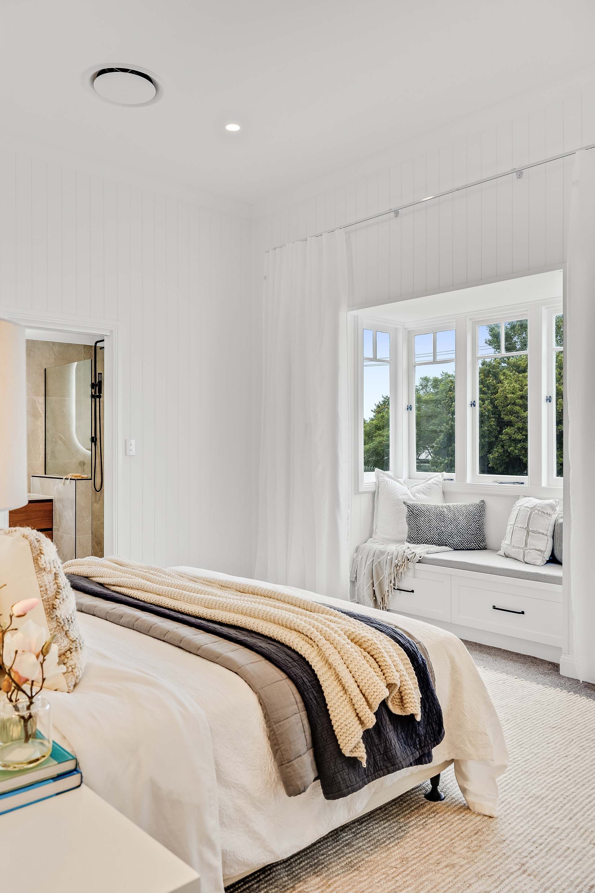 a bedroom with a bed and a window seat .