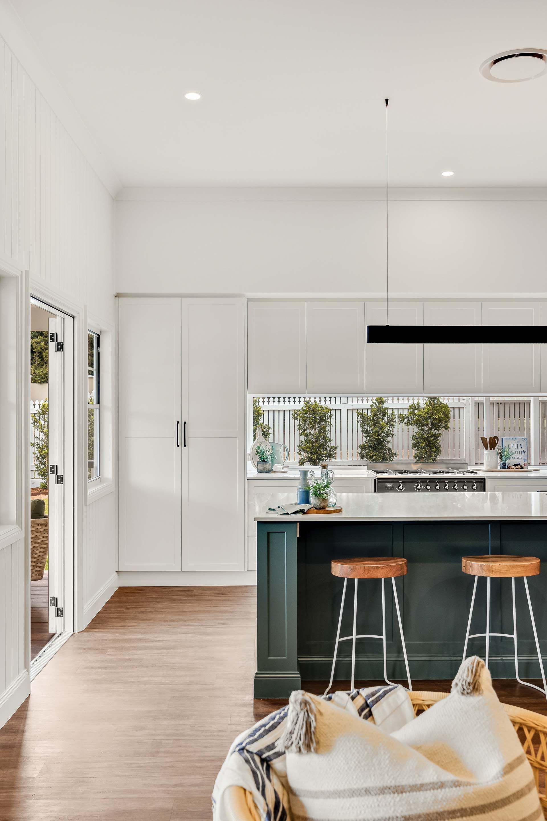 a kitchen with a green island and white cabinets