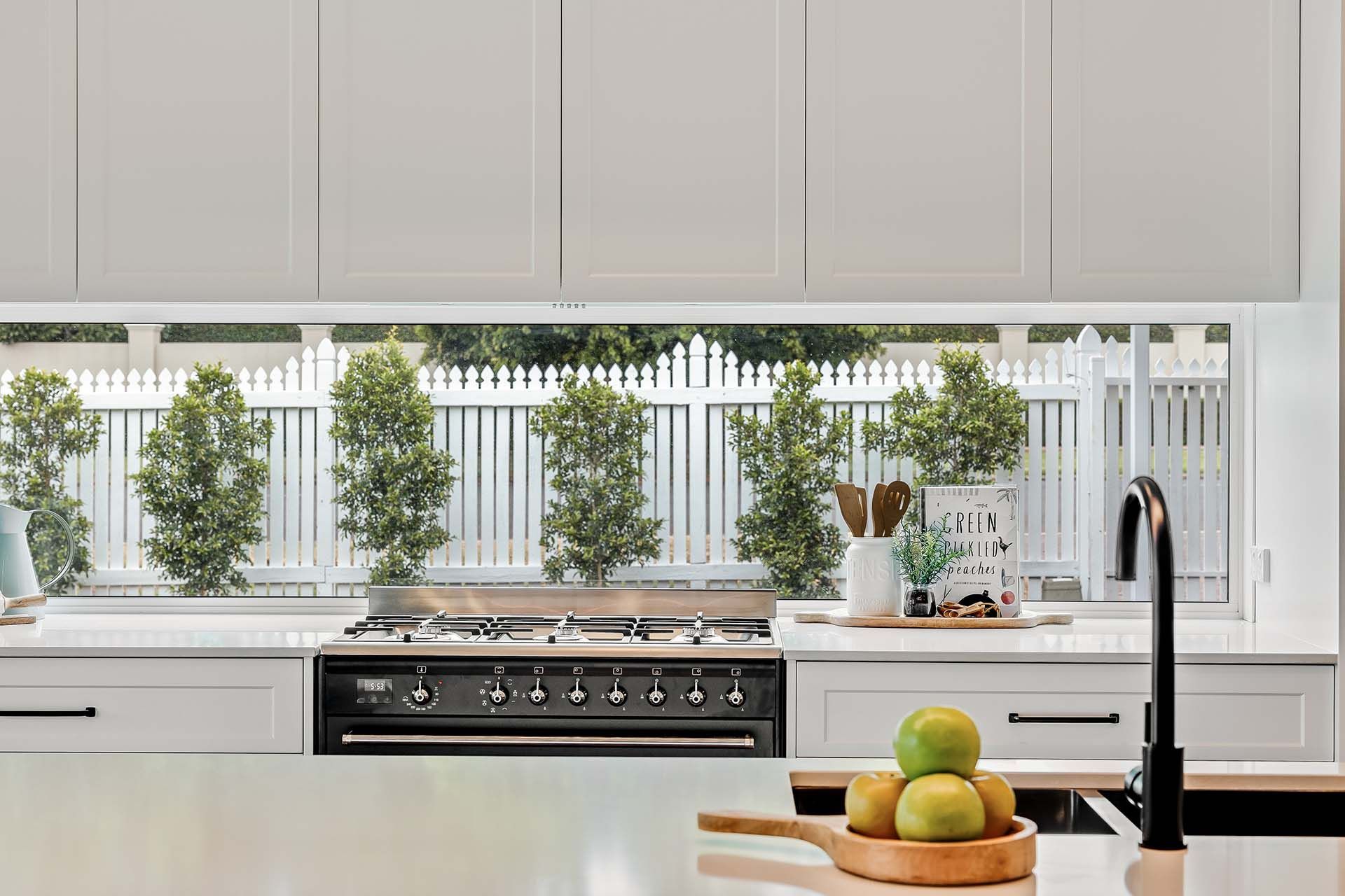 a kitchen with white cabinets and a black stove top oven .