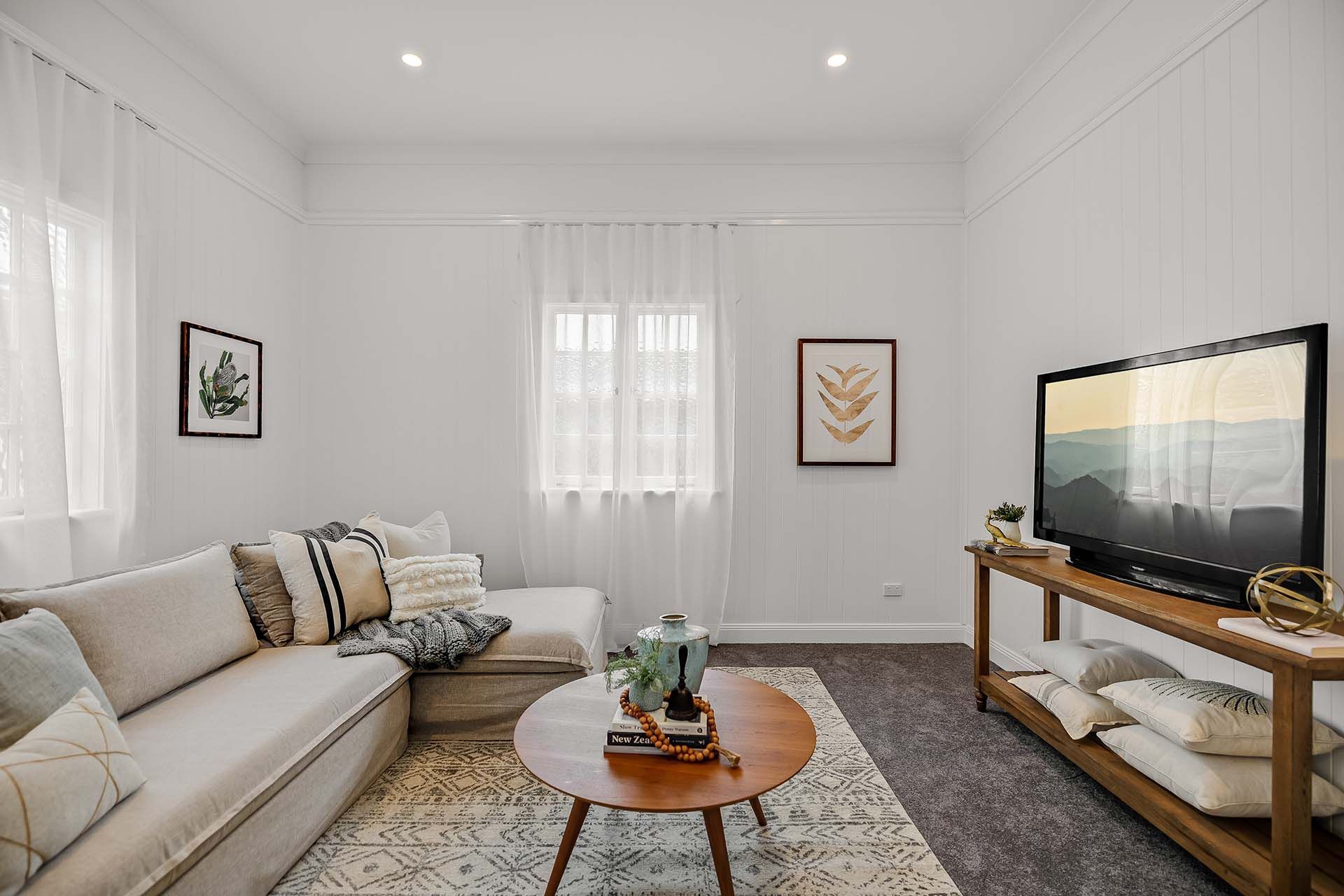 a living room with a couch , coffee table , and television .