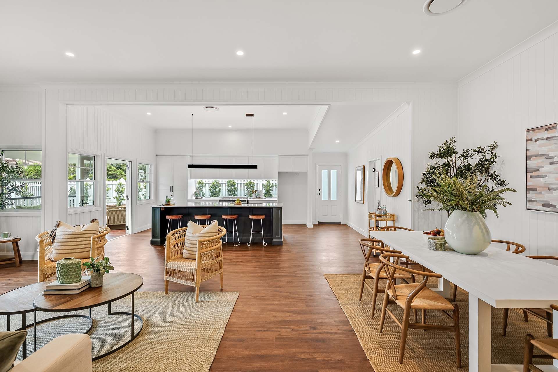 a living room and dining room in a house with a long table and chairs .