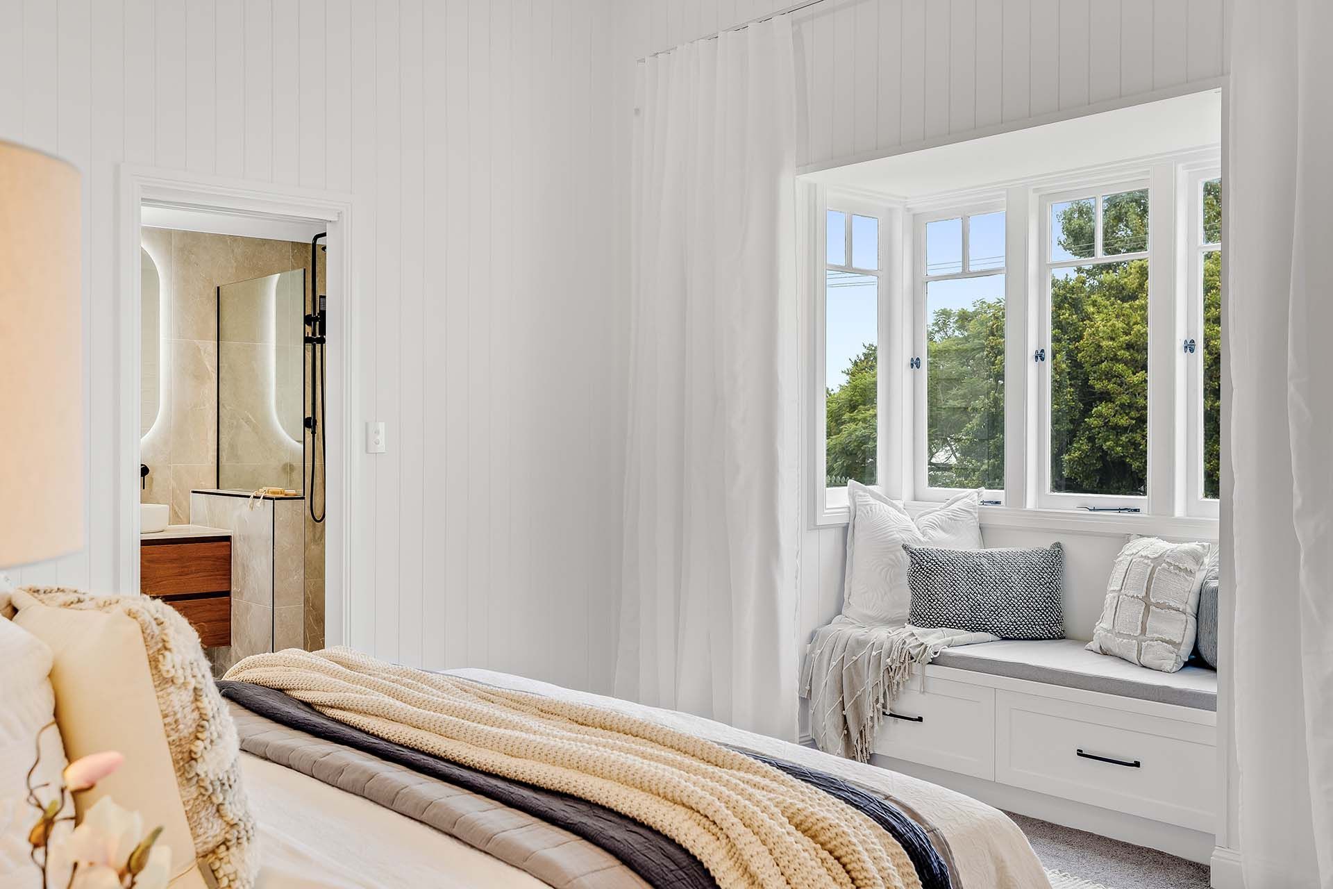 a bedroom with a bed and a window seat .