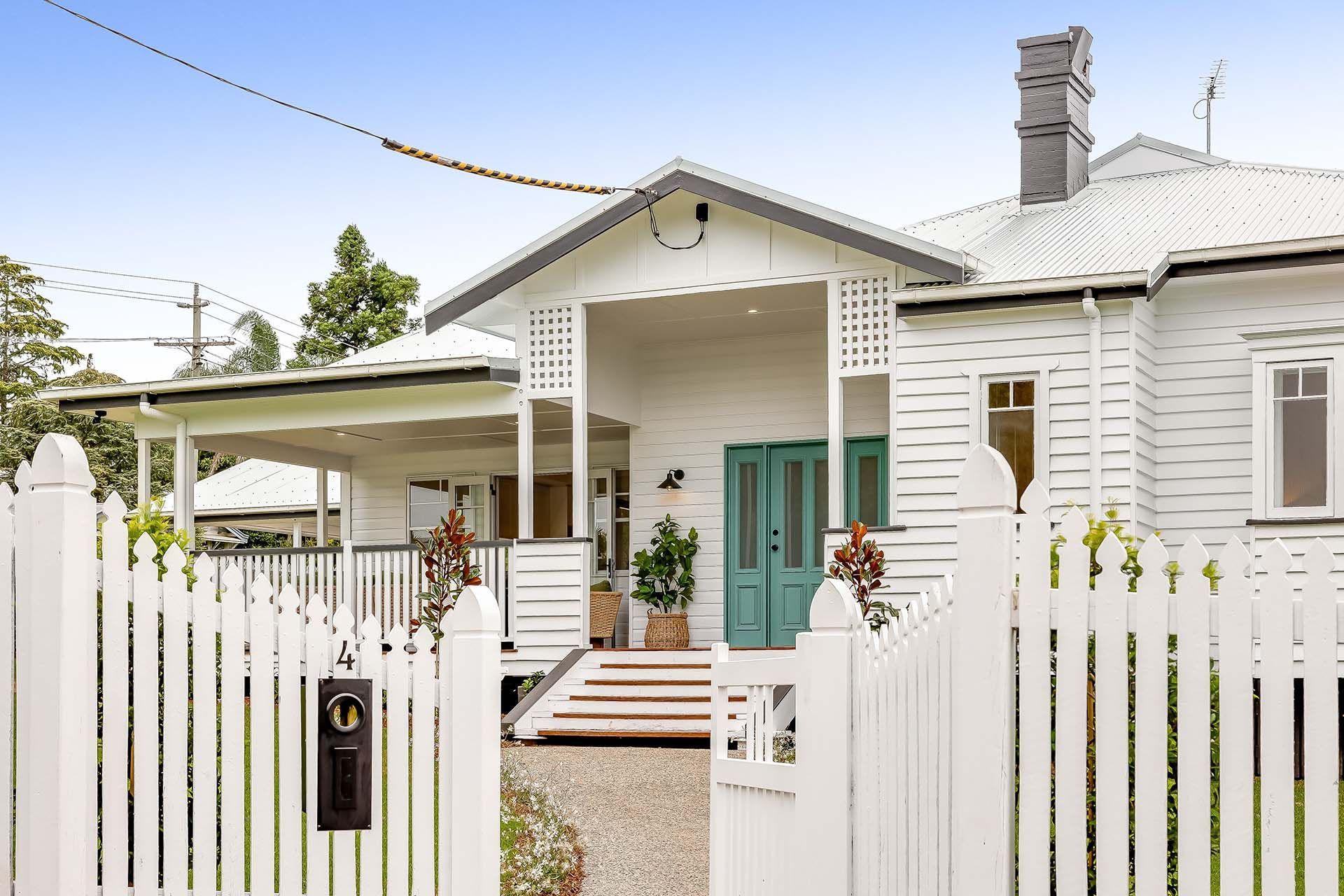 a white house with a green door and a white picket fence .