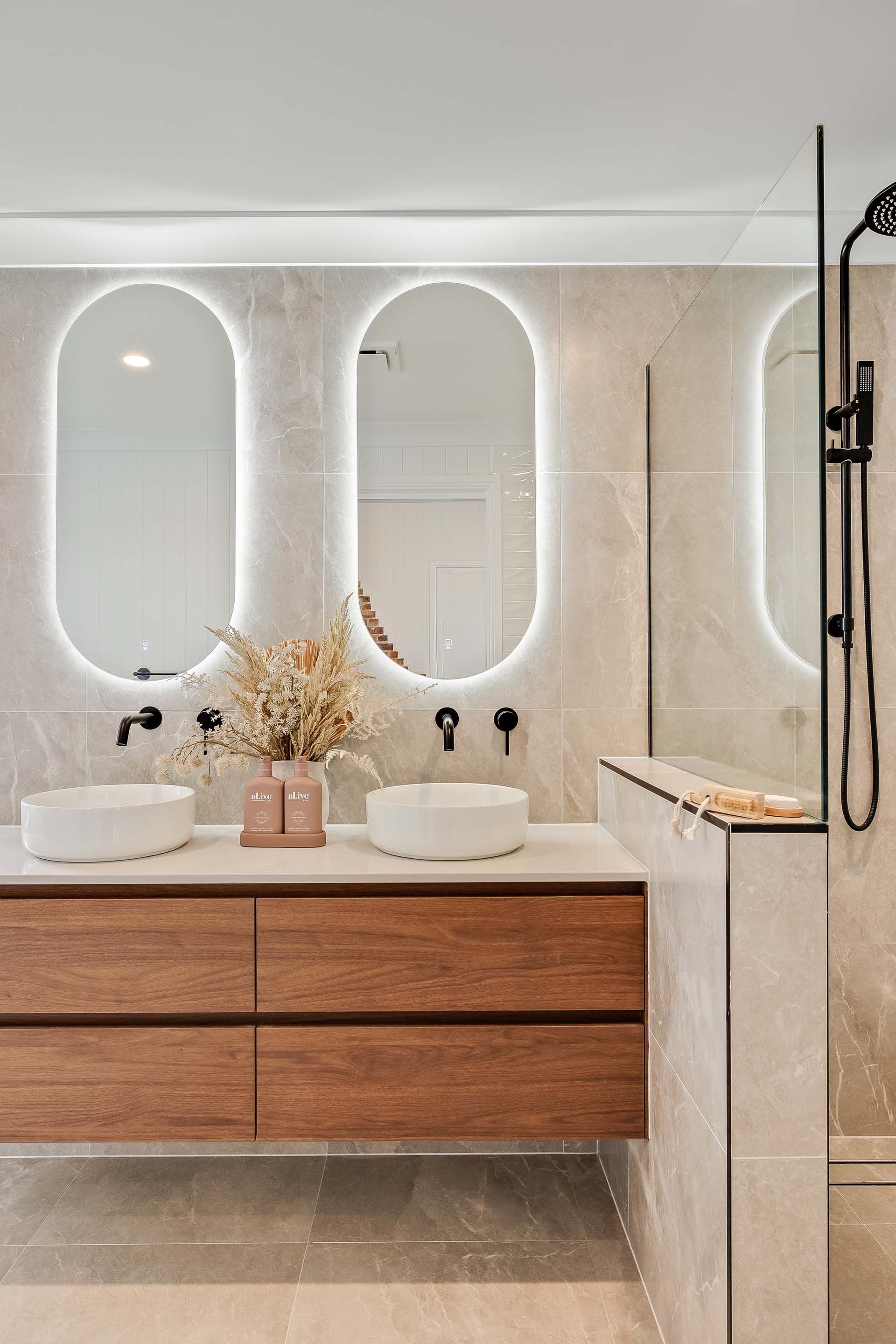 a bathroom with two sinks and two mirrors .