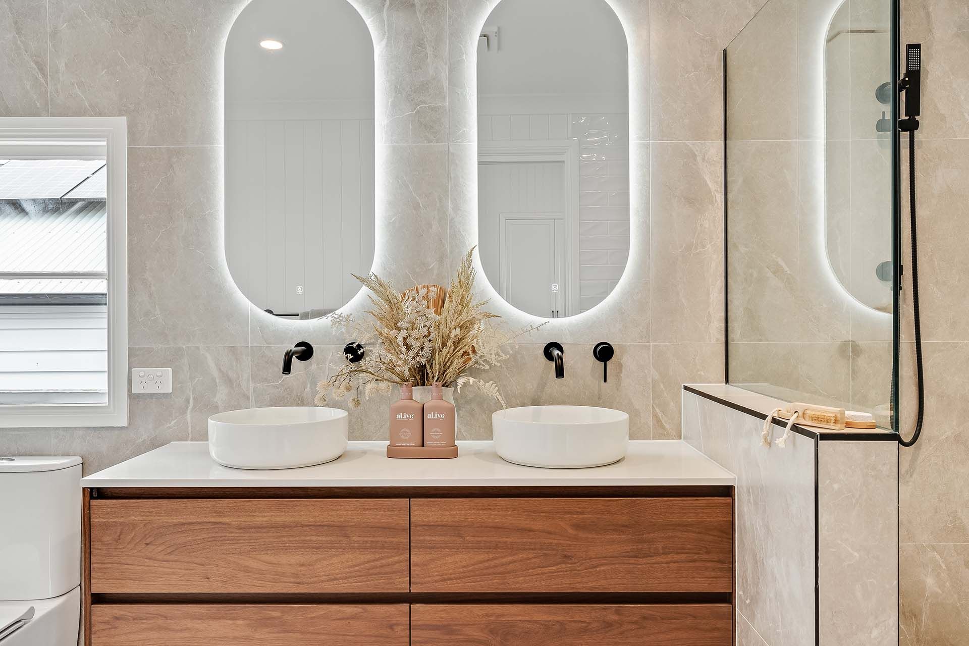a bathroom with two sinks and two mirrors .