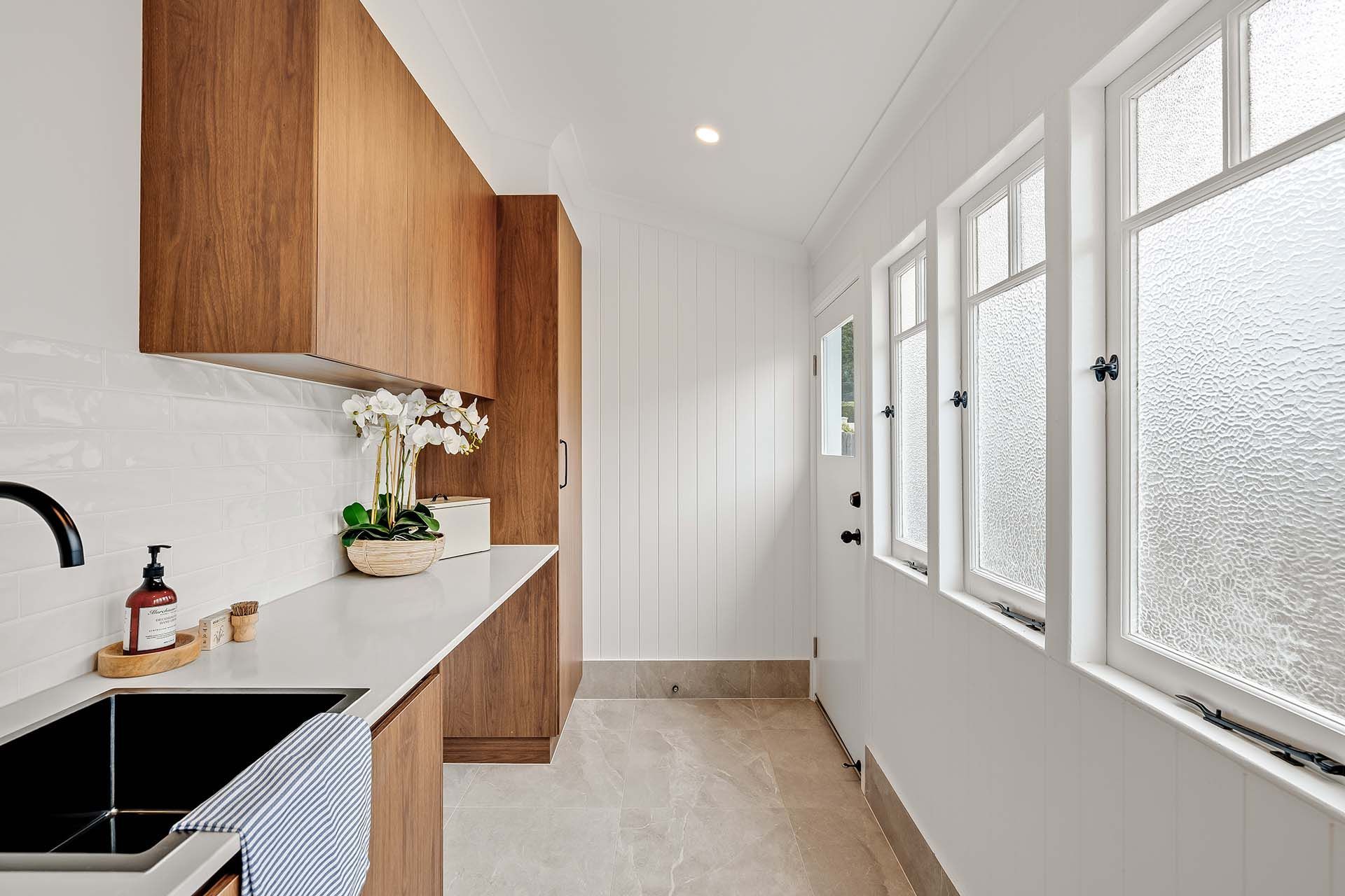 a kitchen with a sink and a lot of windows .