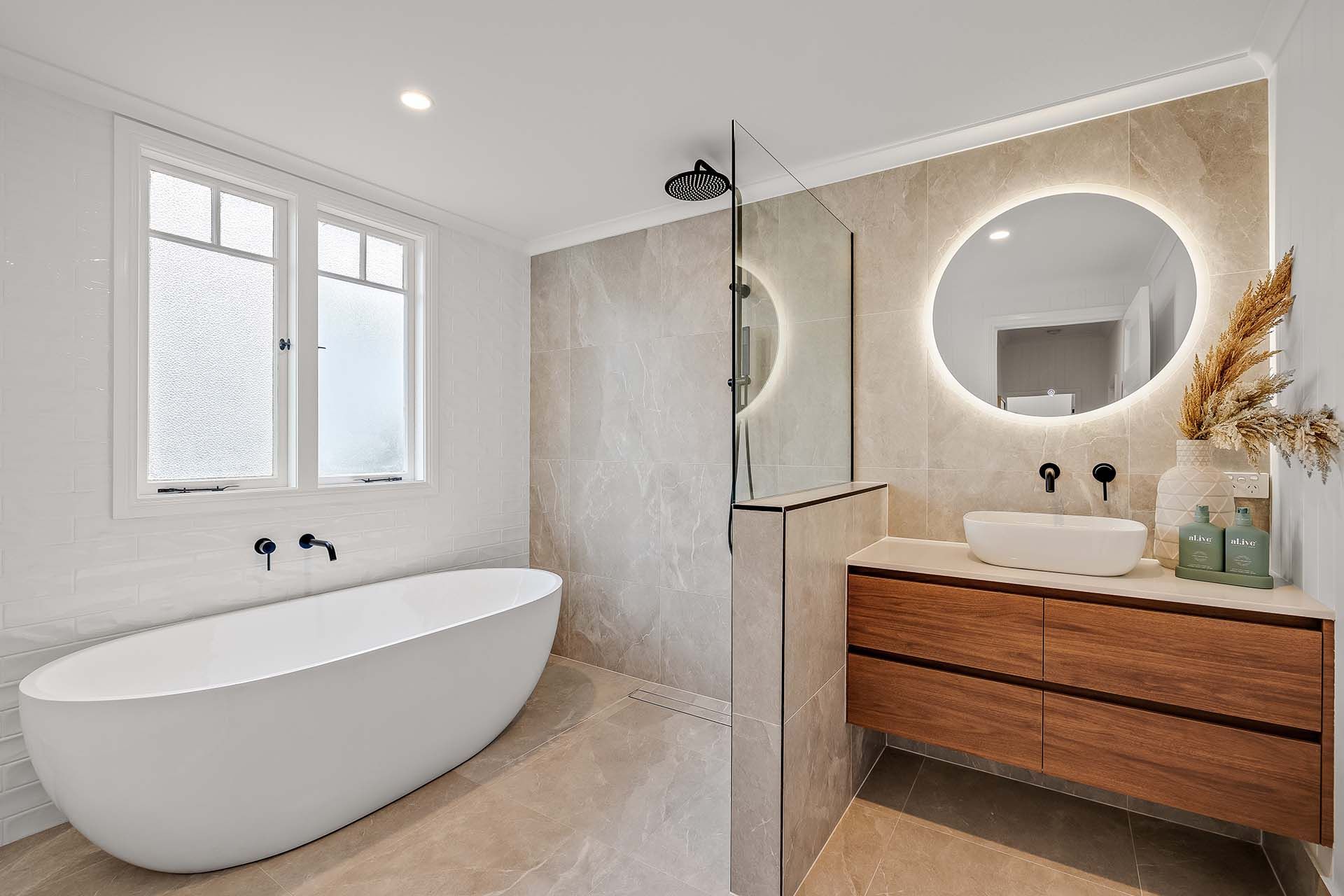 a bathroom with a bathtub , sink , mirror and walk in shower .