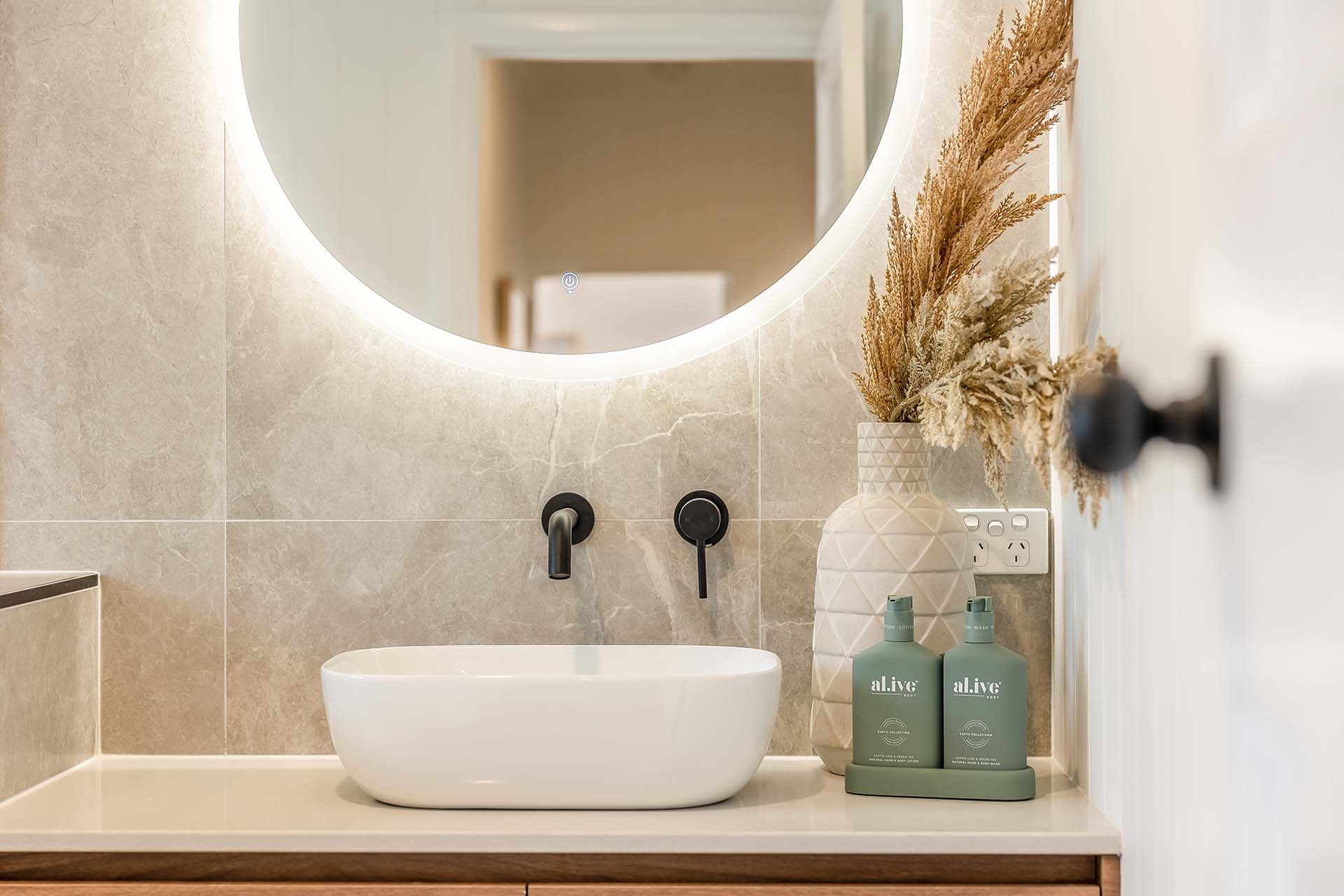 a bathroom with a sink and a round mirror .